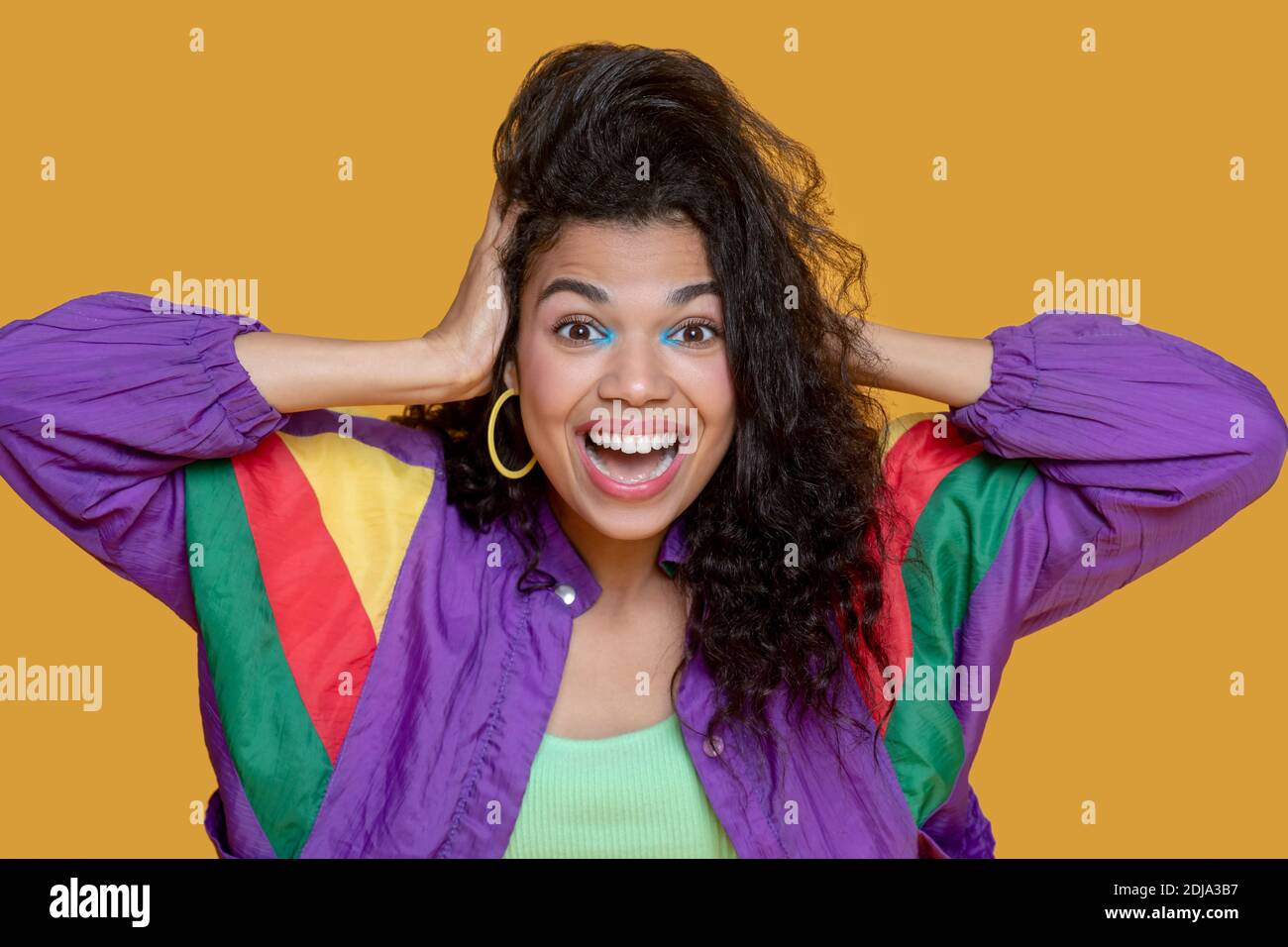 Cute Dark Haired Young Girl In Bright Jacket Holding Her Head Stock