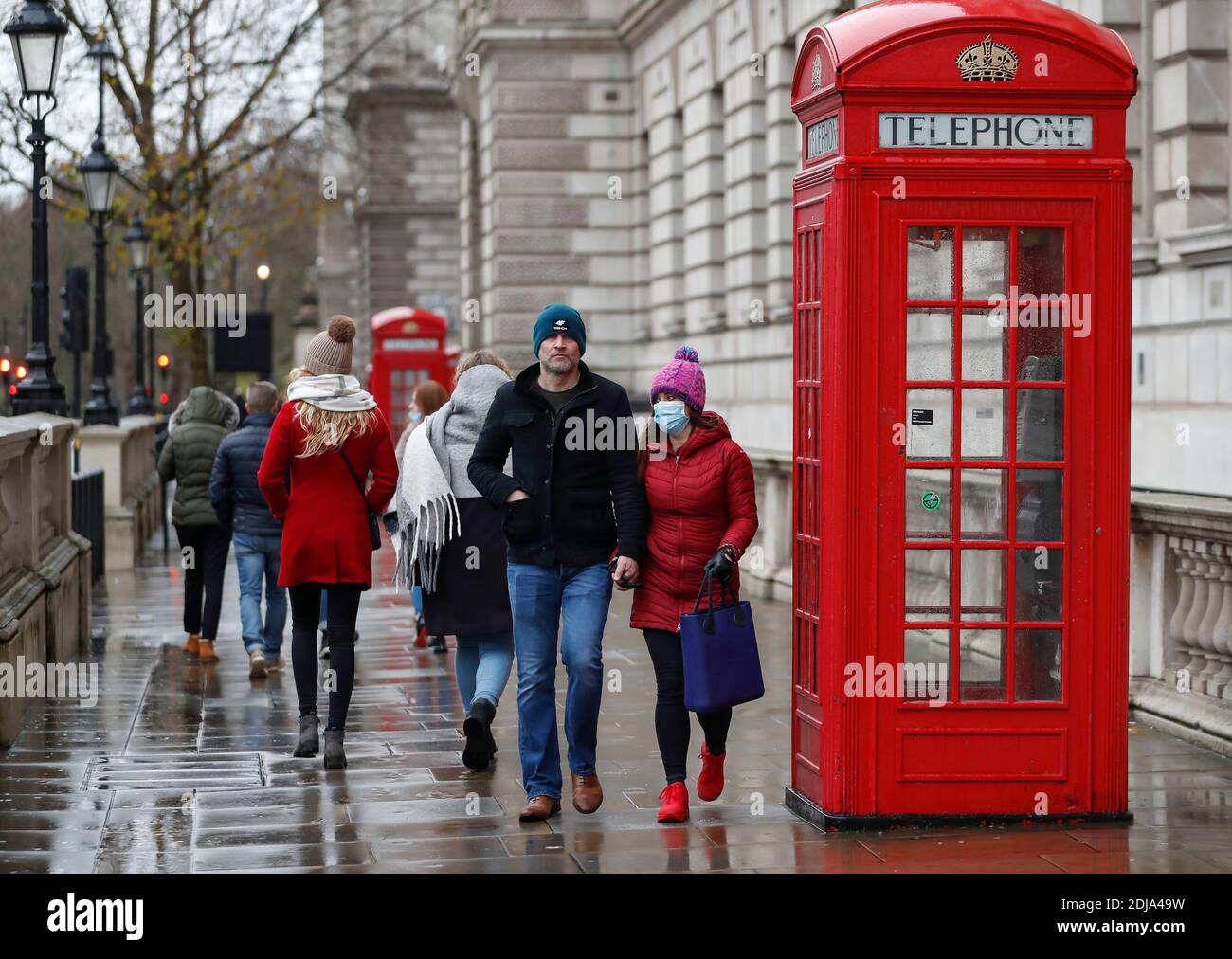 London, Britain. 13th Dec, 2020. People wearing face masks walk past a red telephone box in central London, Britain, on Dec. 13, 2020. Britons who have been in contact with someone who has tested positive for coronavirus will have to self-isolate for 10 days instead of 14, Britain's chief medical officers announced Friday. The new measure, coming into effect from Monday, also applies to those required to quarantine after returning from countries which are not on Britain's travel corridor list. Credit: Han Yan/Xinhua/Alamy Live News Stock Photo