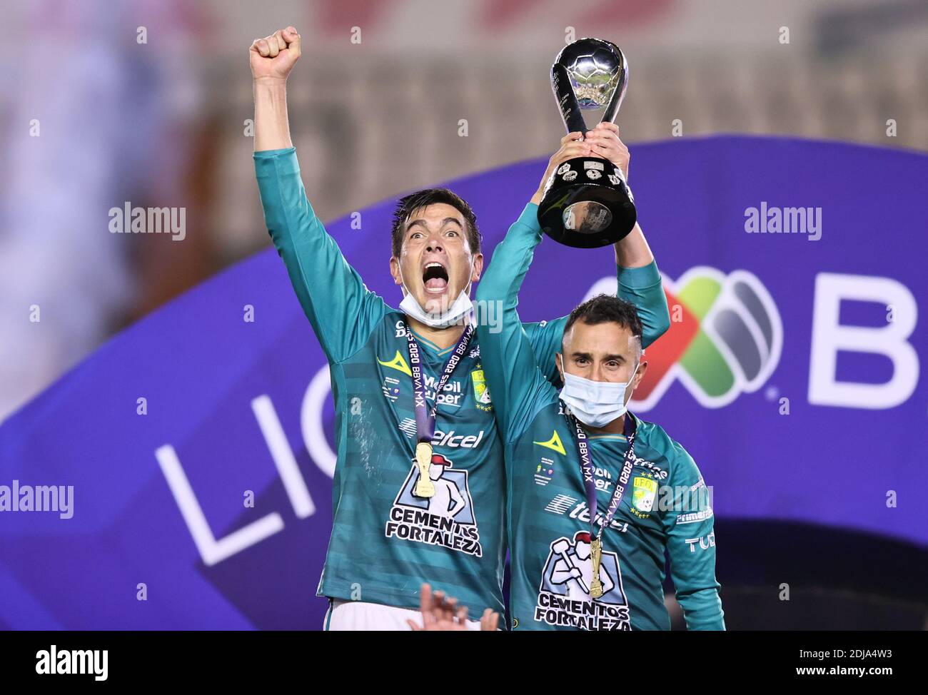 (201214) -- LEON, Dec. 14, 2020 (Xinhua) -- Leon's Juan Gonzalez (L) and Luis Montes celebrate with the trophy after the second leg of the final of the 2020 Liga MX Guardianes tournament against UNAM Pumas in Leon, Mexico, on Dec. 13, 2020. (Xinhua/Carlos Ramirez/Straffon Images) (vf) Stock Photo