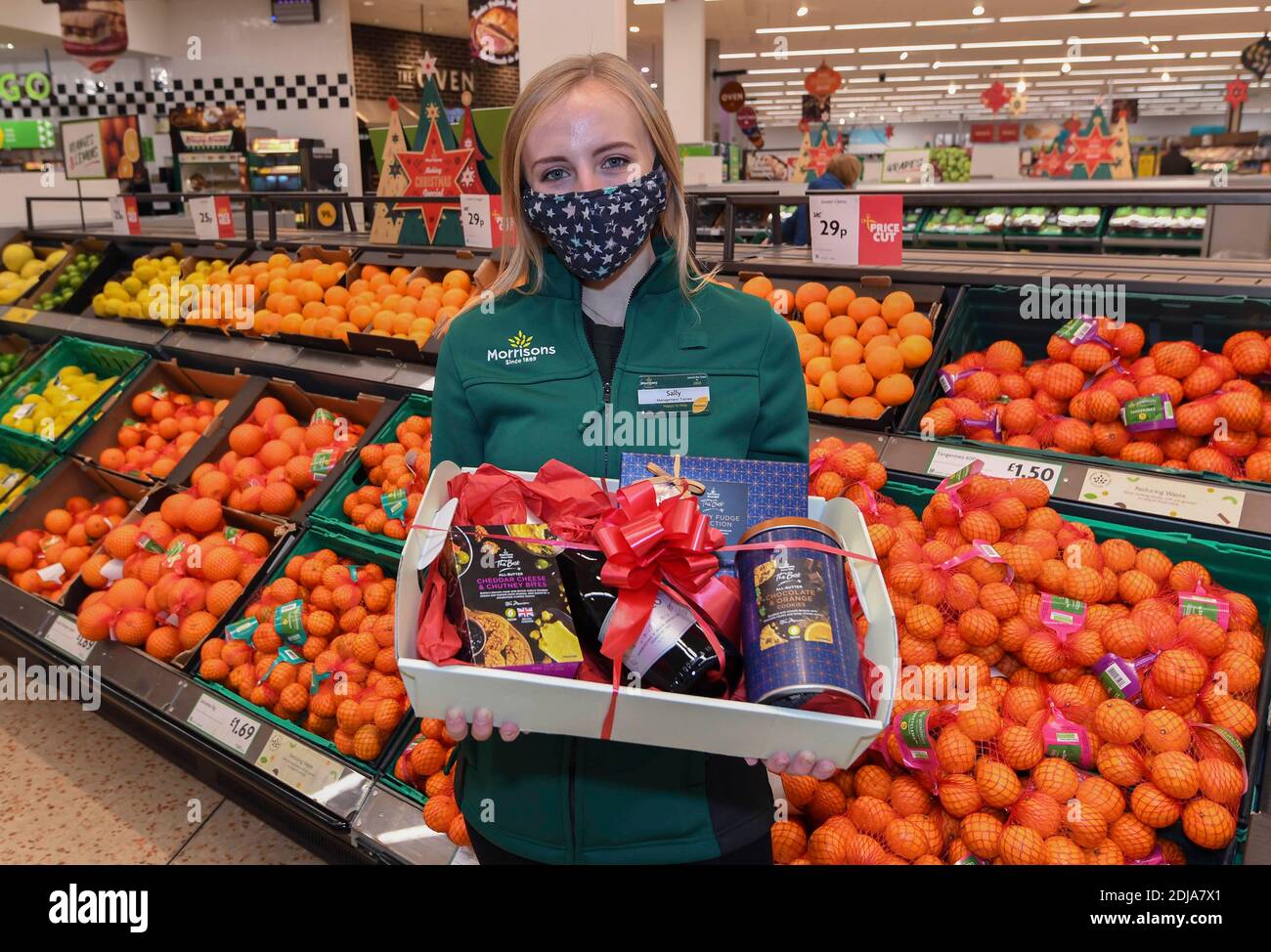 EDITORIAL USE ONLY Staff member Sally O'Hara helps launch the Morrisons Acts of Community Kindness campaign, which will see the supermarket carry out over six thousand acts of kindness this Christmas, including delivering over 100,000 free mince pies to care homes, giving away flowers in local communities and surprising Covid-19 heroes with festive hampers. Stock Photo