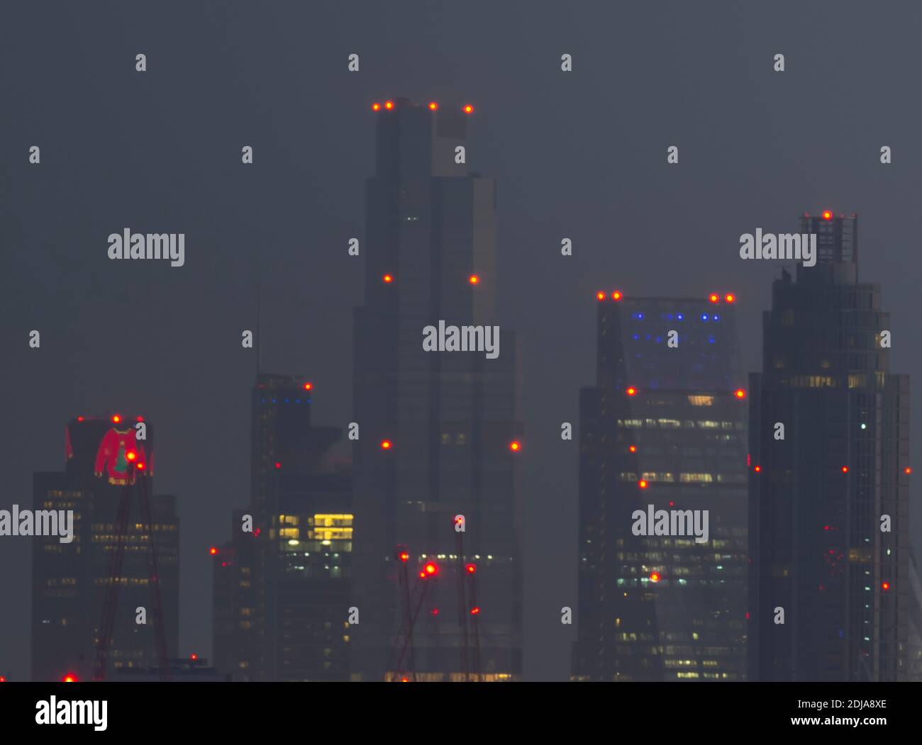 London, UK. 14 December 2020. City of London skyscraper illuminated before sunrise with christmas lights at Tower 42, previously the NatWest Tower (left), wearing a seasonal wooly jumper. Credit: Malcolm Park/Alamy Stock Photo