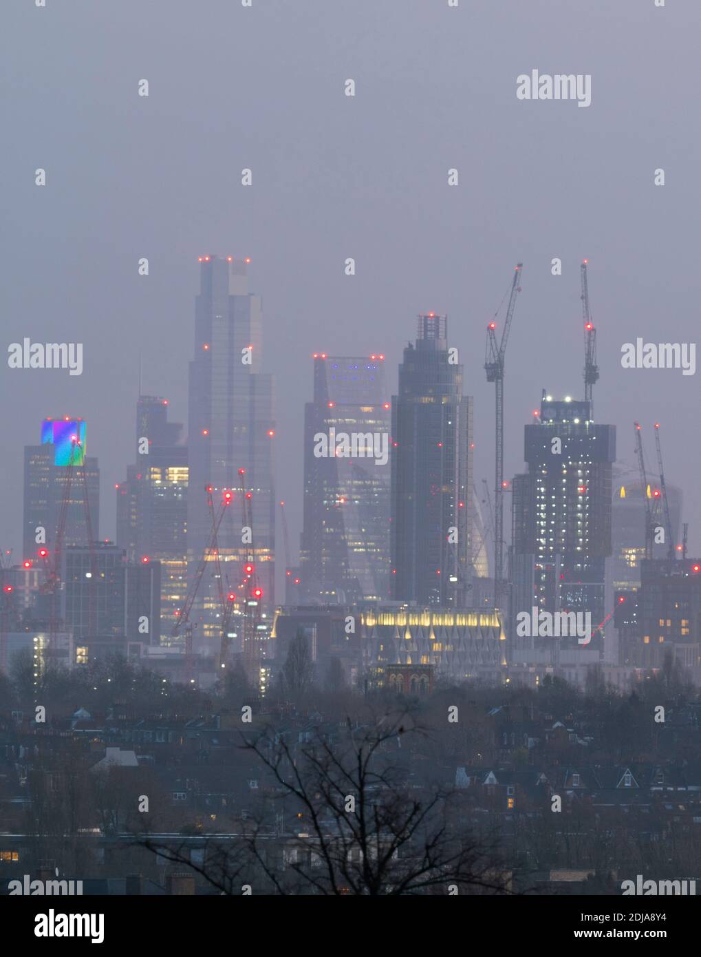 London, UK. 14 December 2020. City of London skyscraper illuminated before sunrise with christmas lights at Tower 42, previously the NatWest Tower (left), viewed from a point 12km distant. Credit: Malcolm Park/Alamy Stock Photo