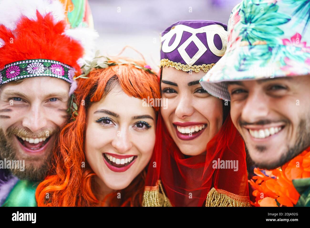 Happy friends celebrating carnival party outdoor - Portrait young crazy people having fun wearing funny costumes Stock Photo
