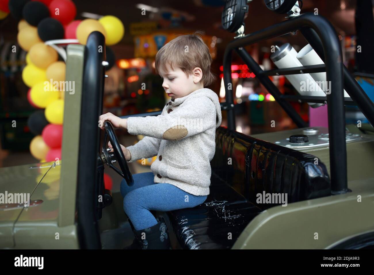 Child driving toy car at amusement park Stock Photo Alamy