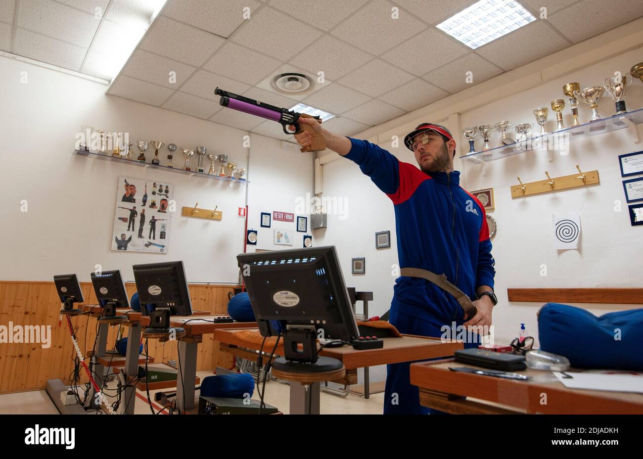 Shooter with professional air gun, during training at the firing range