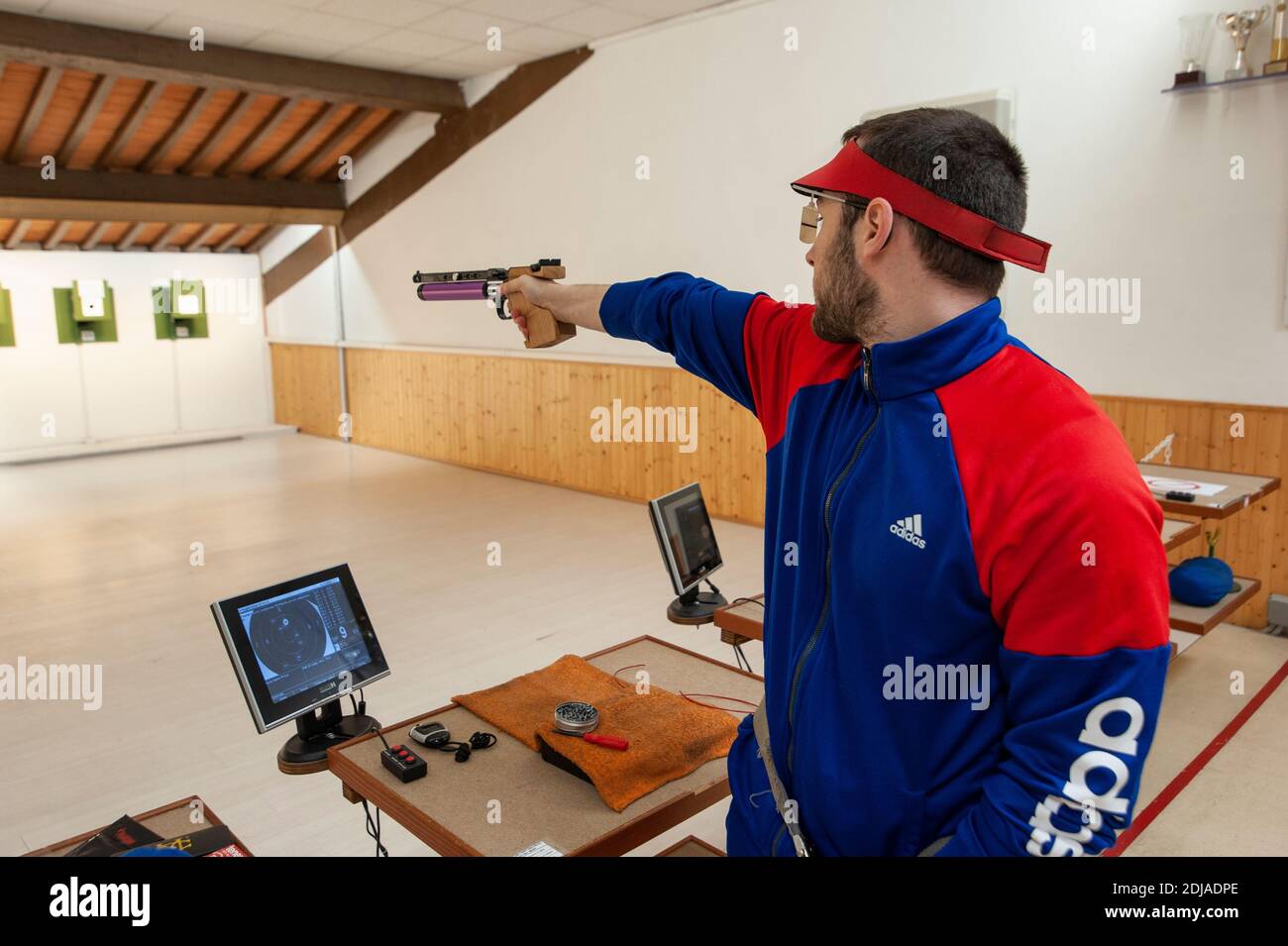 Shooter with professional air gun, during training at the firing range