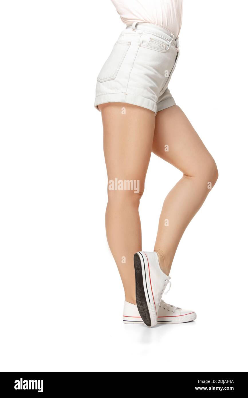 Beautiful legs of young girl in stylish sport shoes isolated on white background Stock Photo