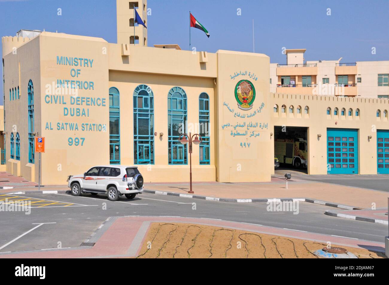 Facade of Dubai Ministry of Interior Civil Defence Al Satwa Fire Staion 997 building with open shutter and fire engine truck United Arab Emirates UAE Stock Photo