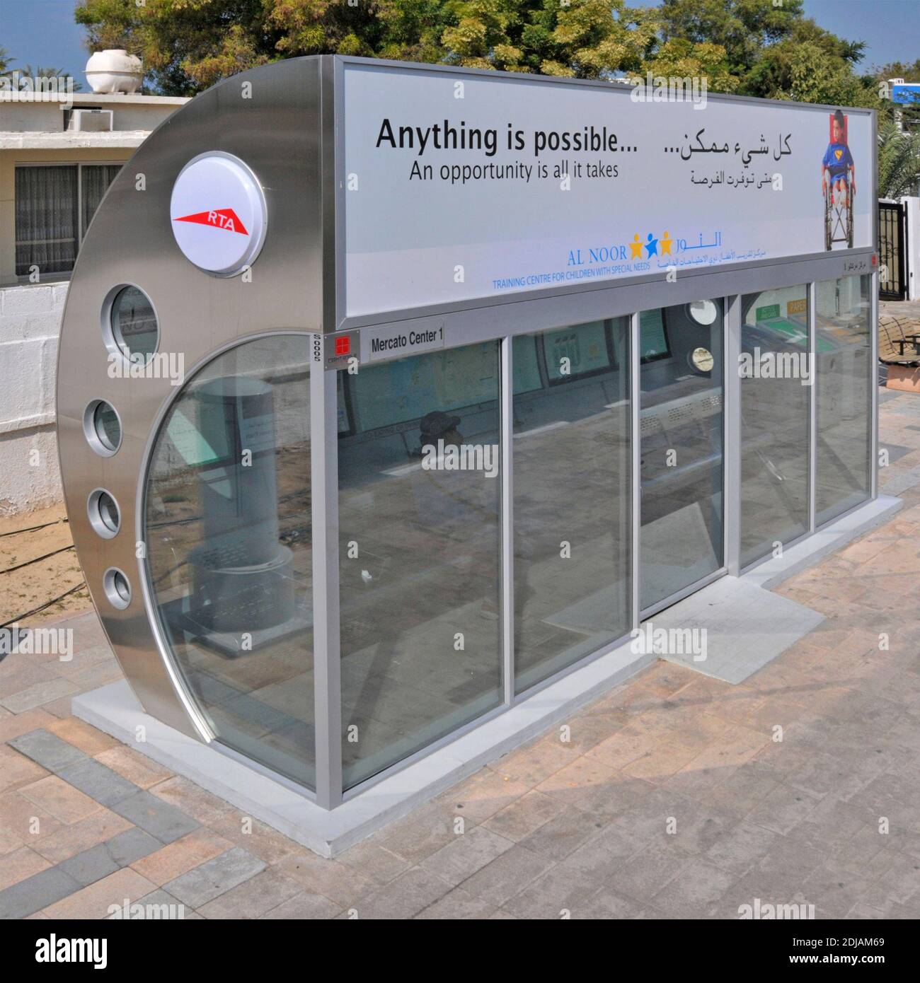 Glass & stainless steel RTA air conditioned bus shelter on pavement bilingual advertising panel at Mercato Center mall Dubai United Arab Emirates UAE Stock Photo