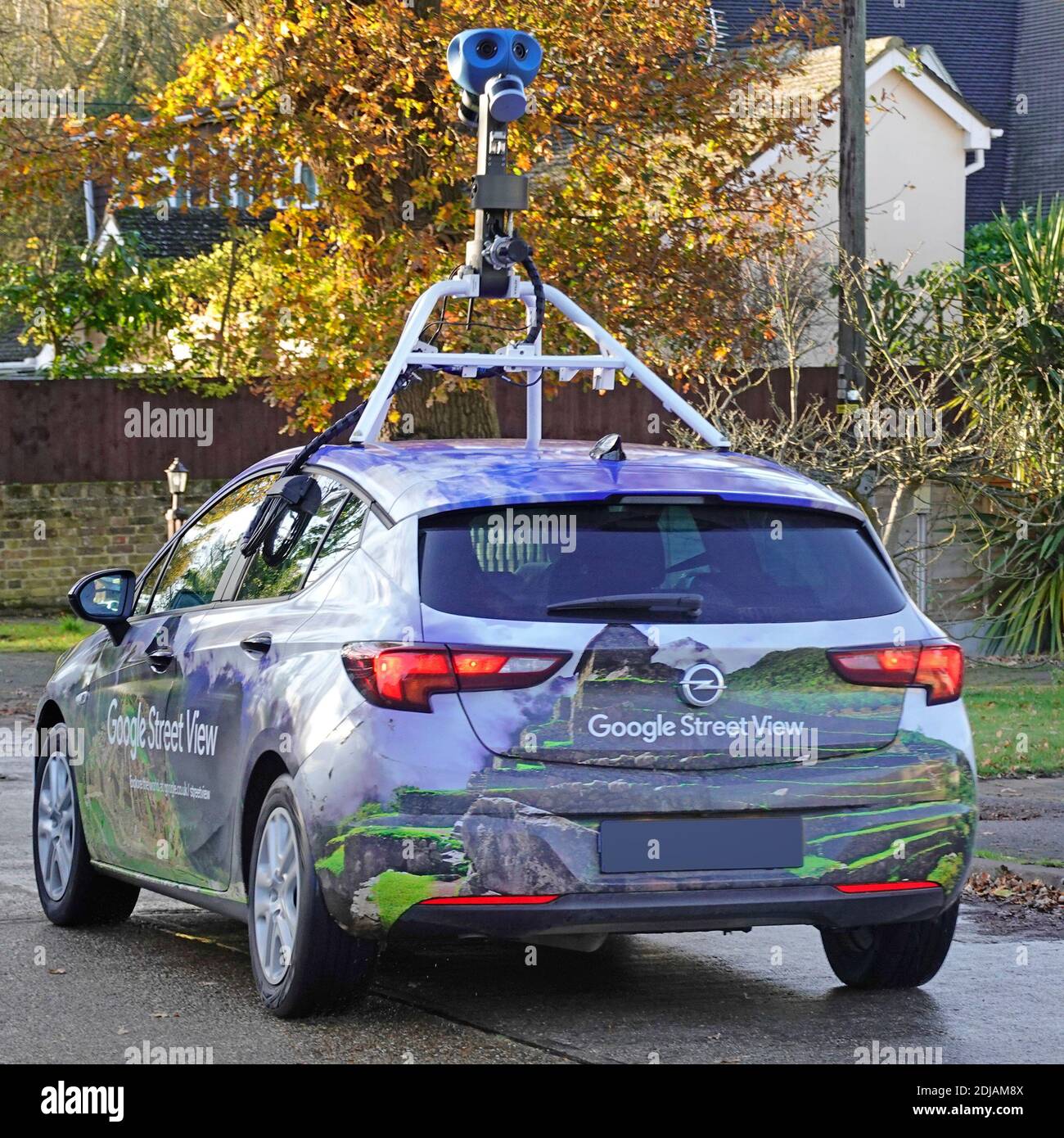 Close up back of Google car & video camera rig fixed into vehicle roof filming street view pegman map images driving residential road Essex England UK Stock Photo