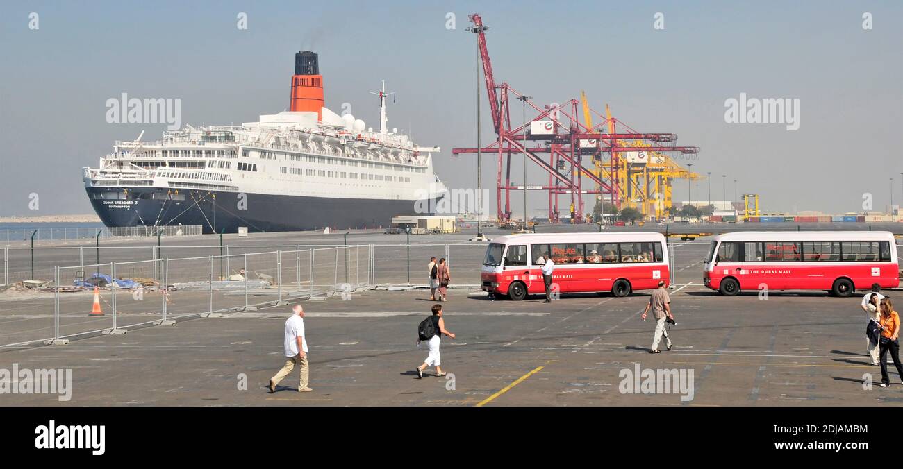 QE2 QEII ex Cunard cruise ship liner at Port Rashid passengers from out of shot cruise ship walking to board bus to The Dubai Mall for shopping UAE Stock Photo
