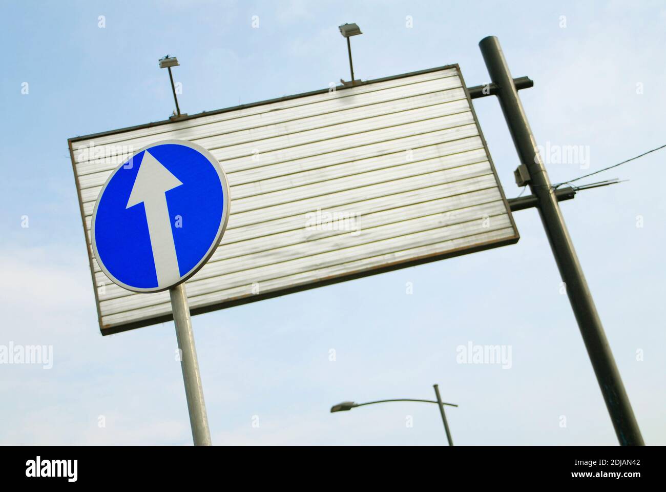 Blue traffic sign and an empty ad board Stock Photo - Alamy