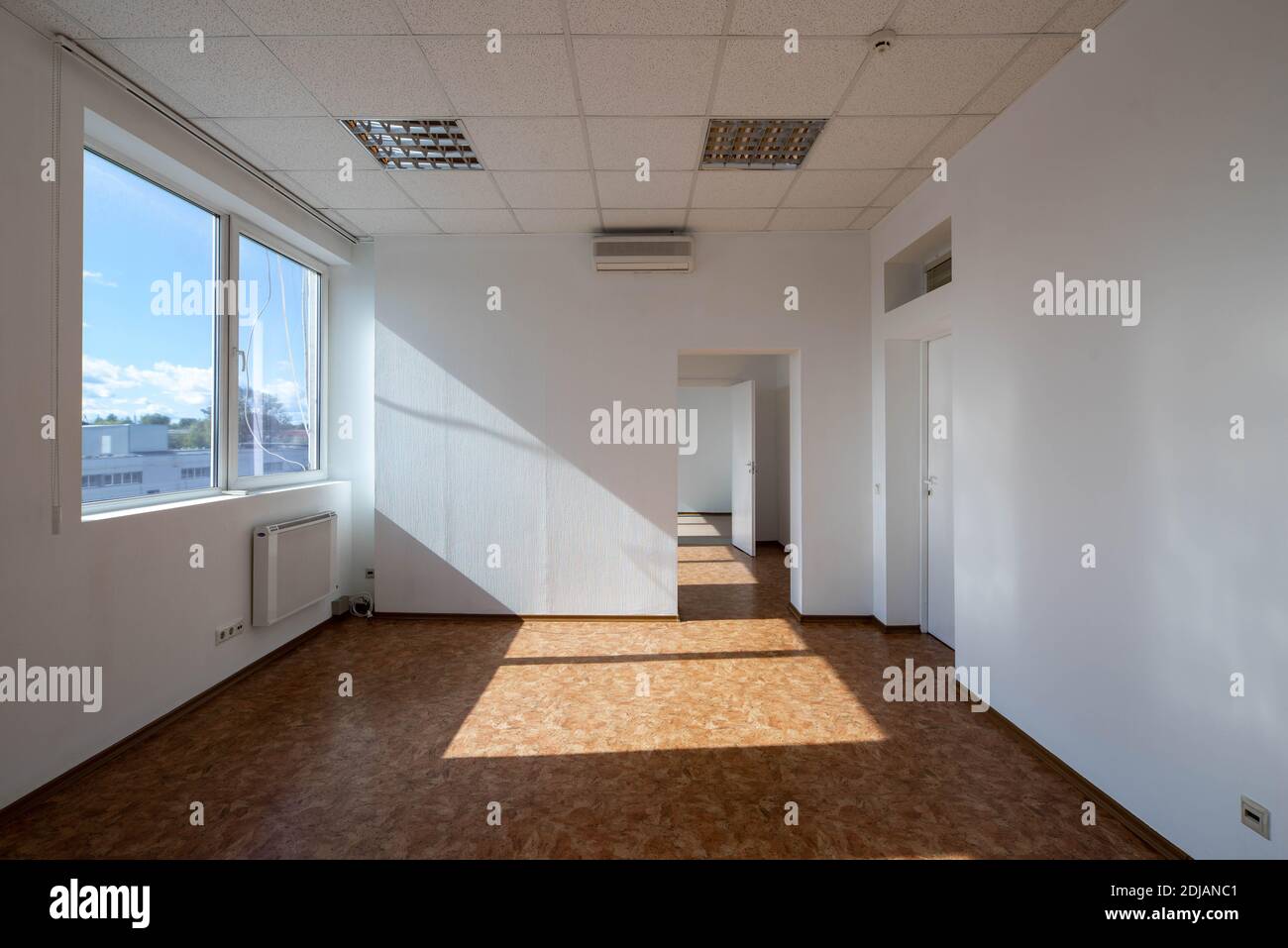 Modern interior of empty office rooms. White walls. Huge window. Sunny day. Stock Photo