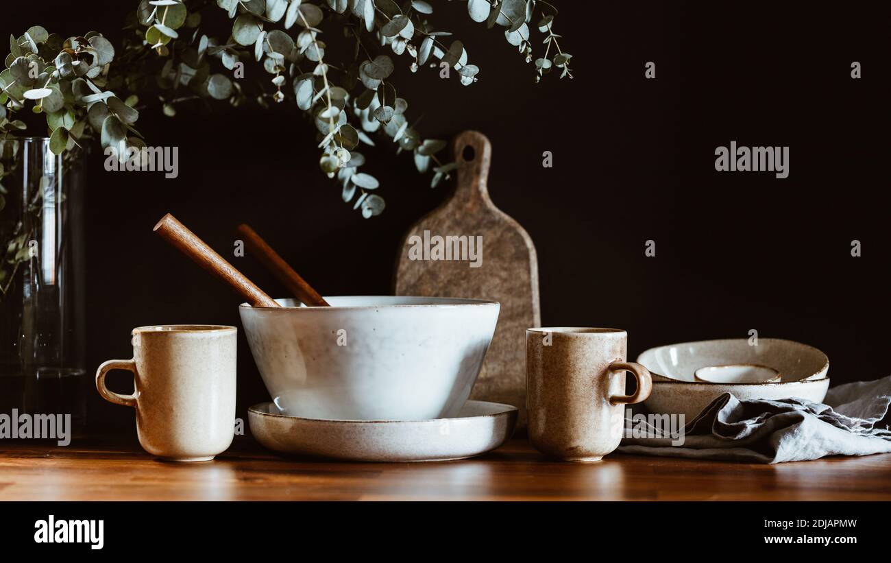 Set of kitchen ceramic tableware and wooden cutting boards on a table ...