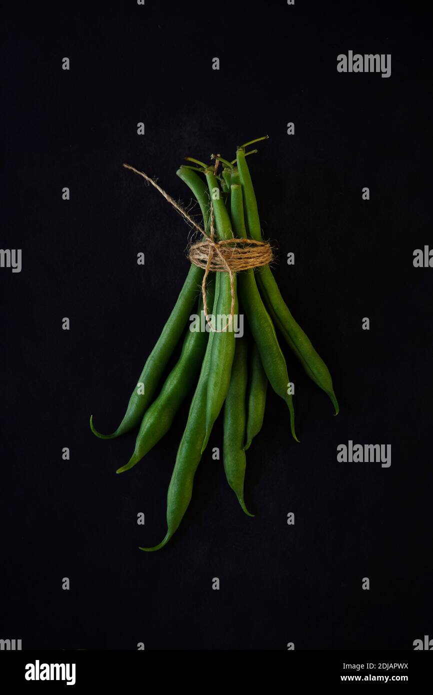 Green string beans on a black background. Healthy organic food