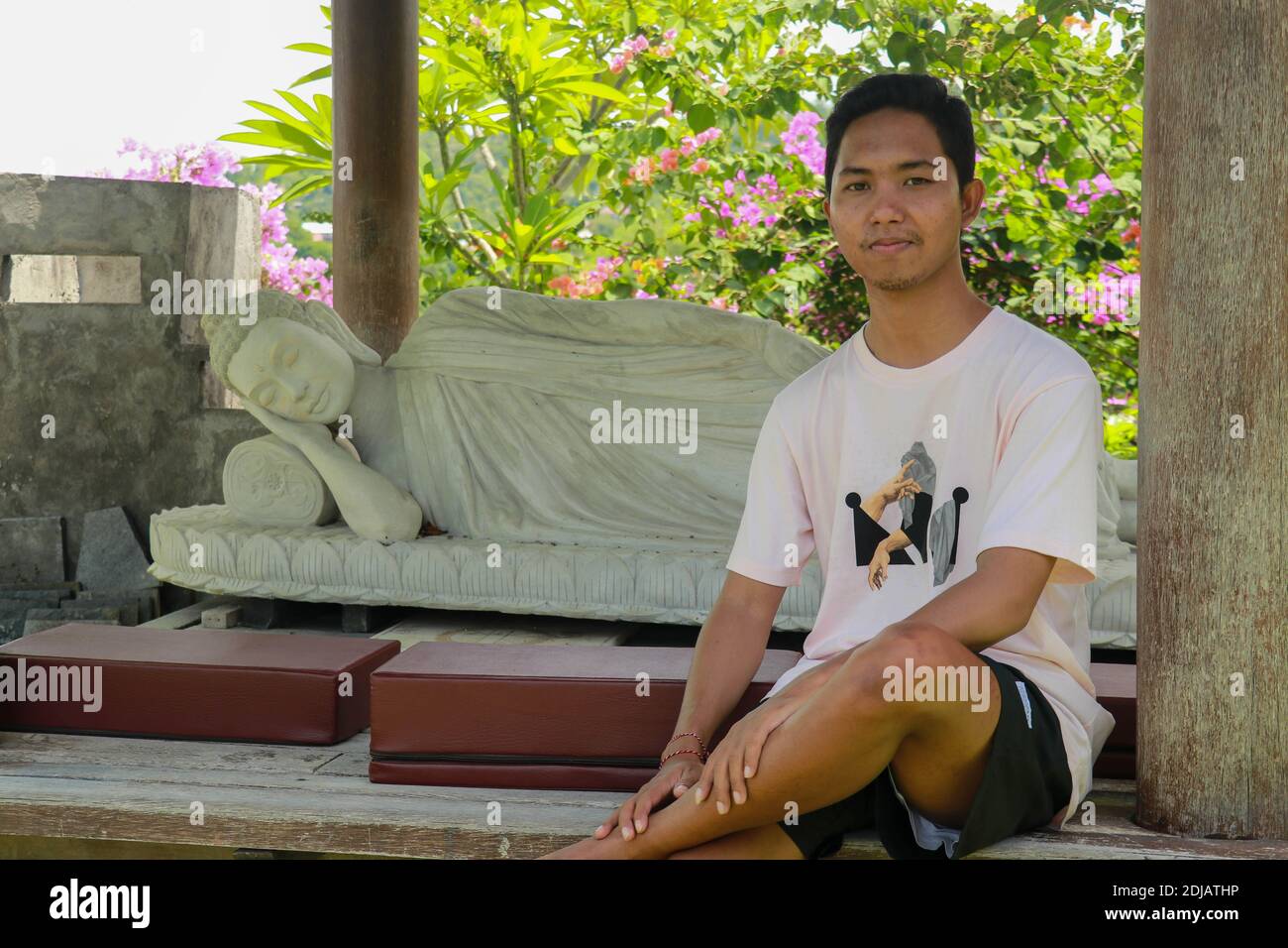 A Young Asian Man Sits By A White Buddha Statue Lying In The Brahma ...