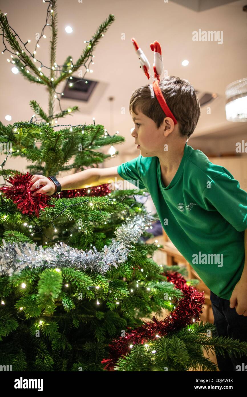 Family at home decorating their Christmas tree ahead of the Xmas