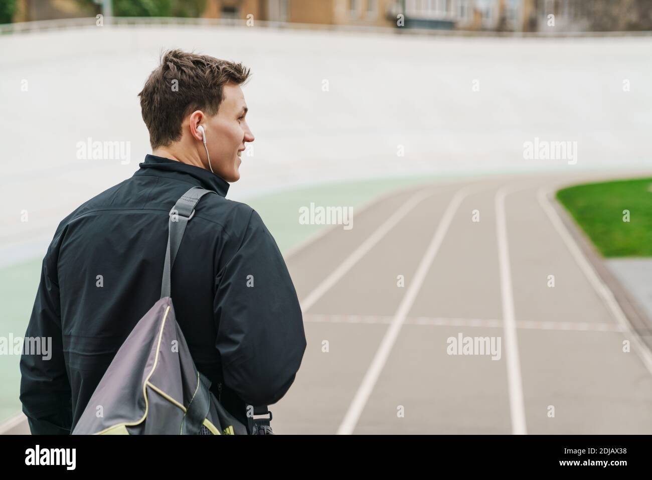 Happy young sportive man walking on stadium, carrying sport bag, back view  Stock Photo - Alamy