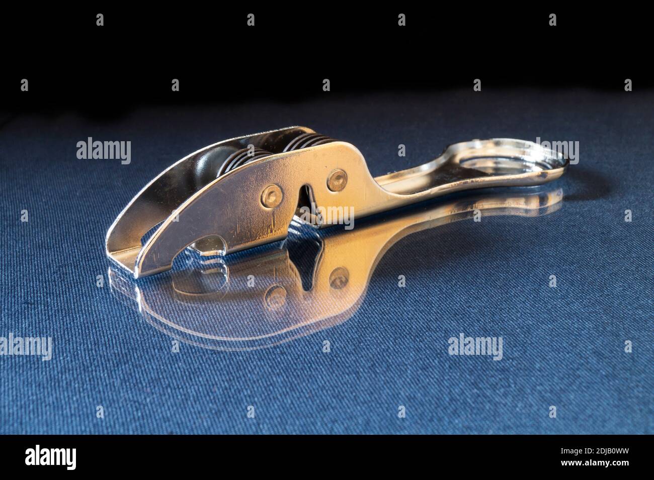 Sharpening the knife from steels rests upon turn blue the table with reflection. Kitchen accesories on black background Stock Photo