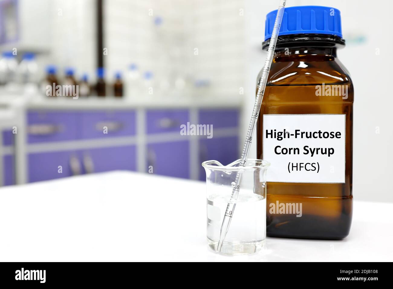 Selective focus of high-fructose corn syrup or hfcs food and beverage sweetener in dark brown glass bottle inside a laboratory. Stock Photo