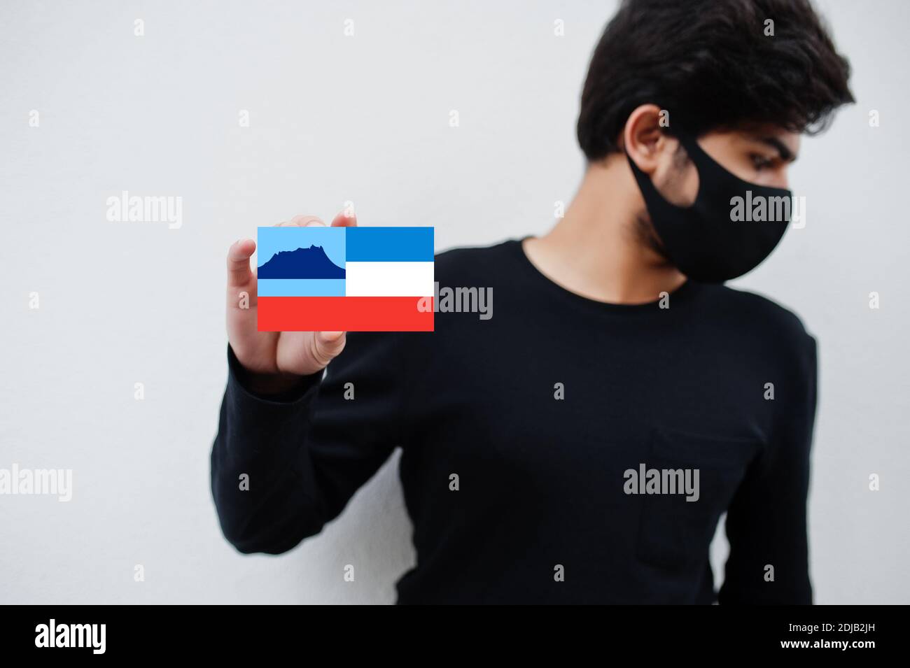 Malay man wear all black with face mask hold Sabah flag in hand