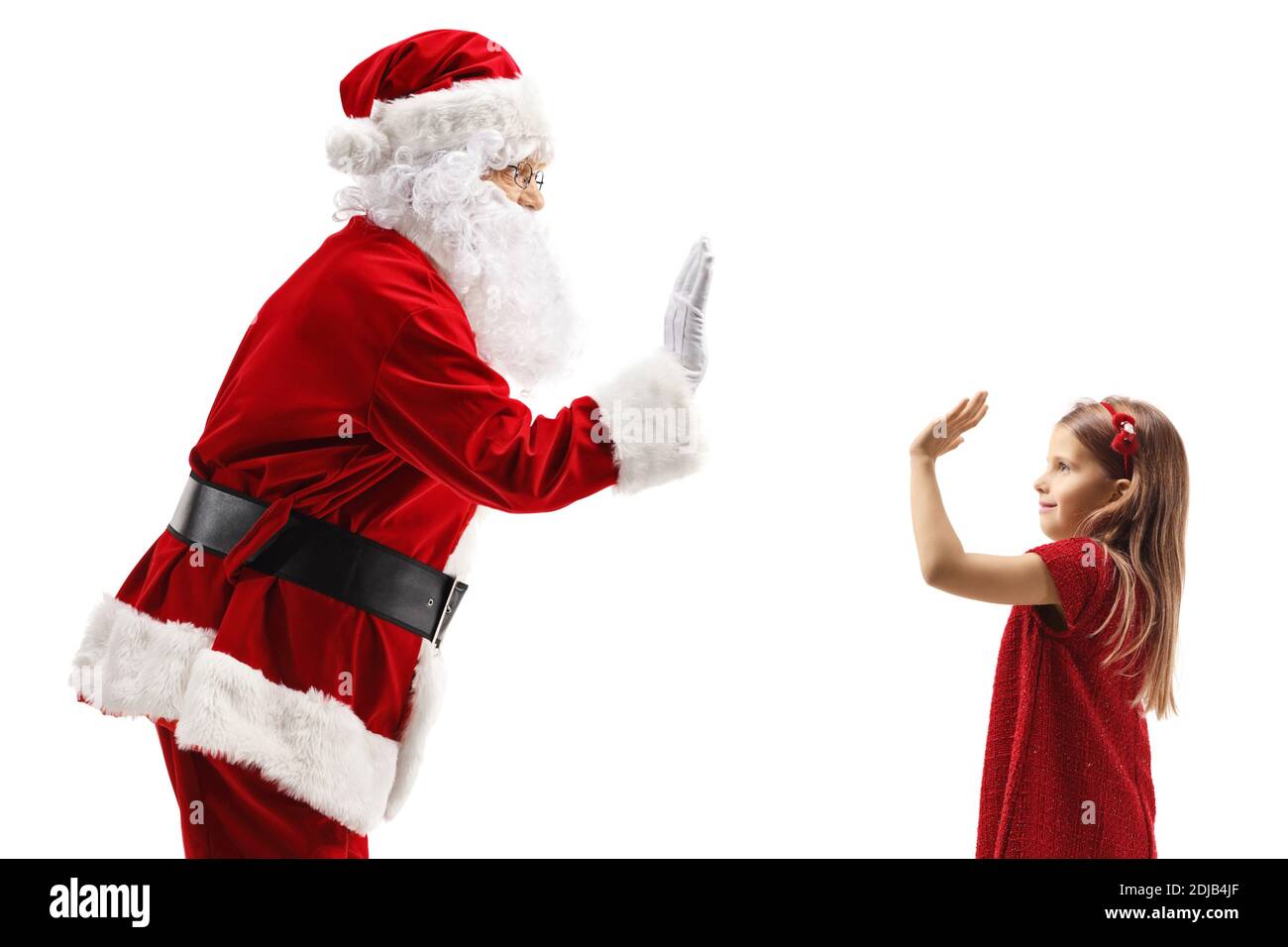 Santa Claus gesturing high-five with a little girl in a red dress isolated on white background Stock Photo