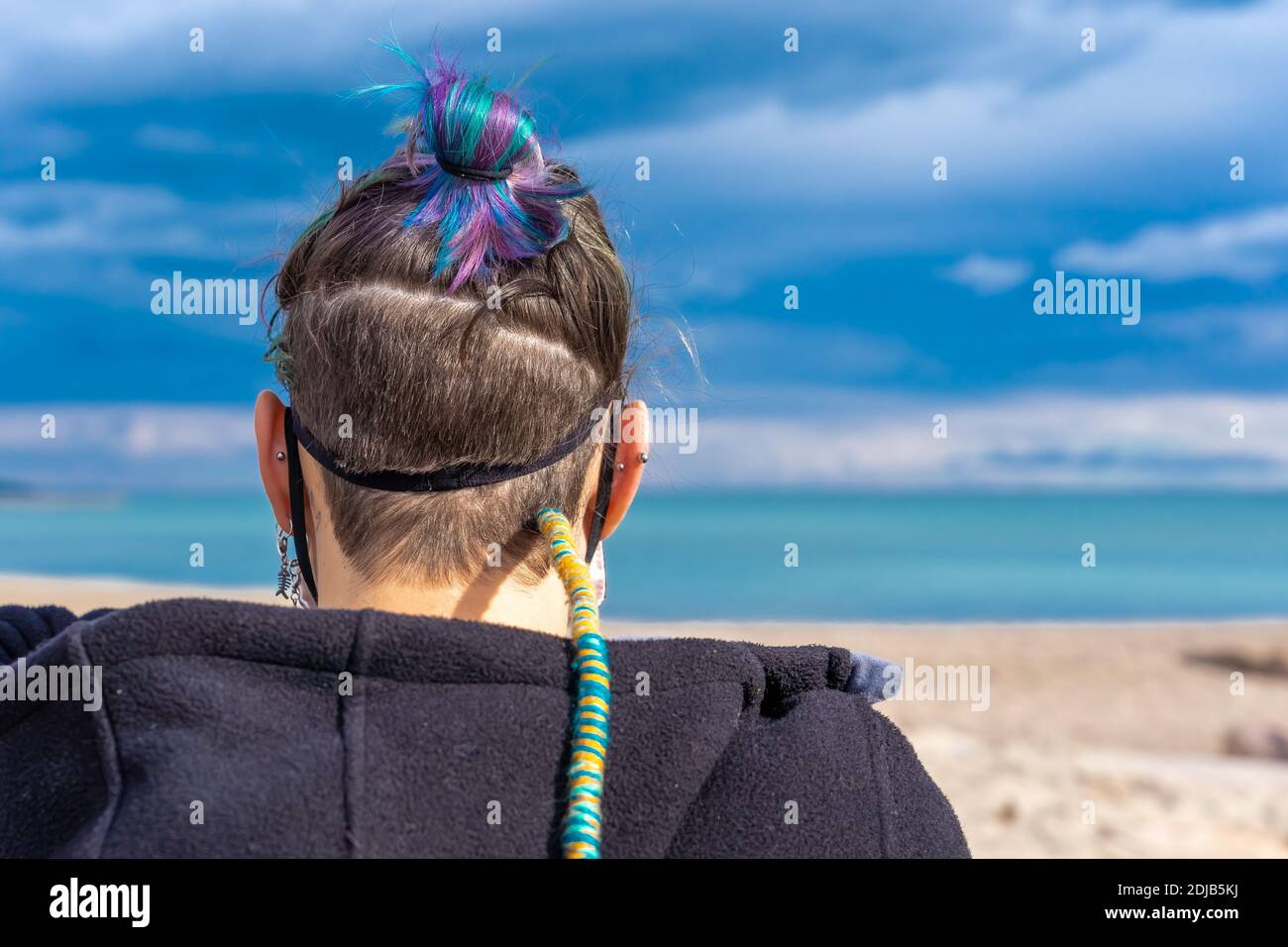 A person with tied colorful hair and a thread braid, taken from behind ...