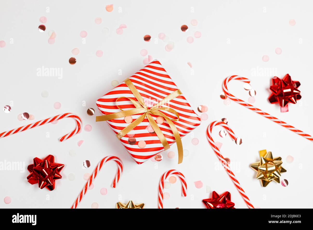 2021 Happy New Year frame composition. Christmas striped design gifts boxes, golden and red bow, candy cane, glitter light on a white background with copy space. Flat lay, top view Stock Photo