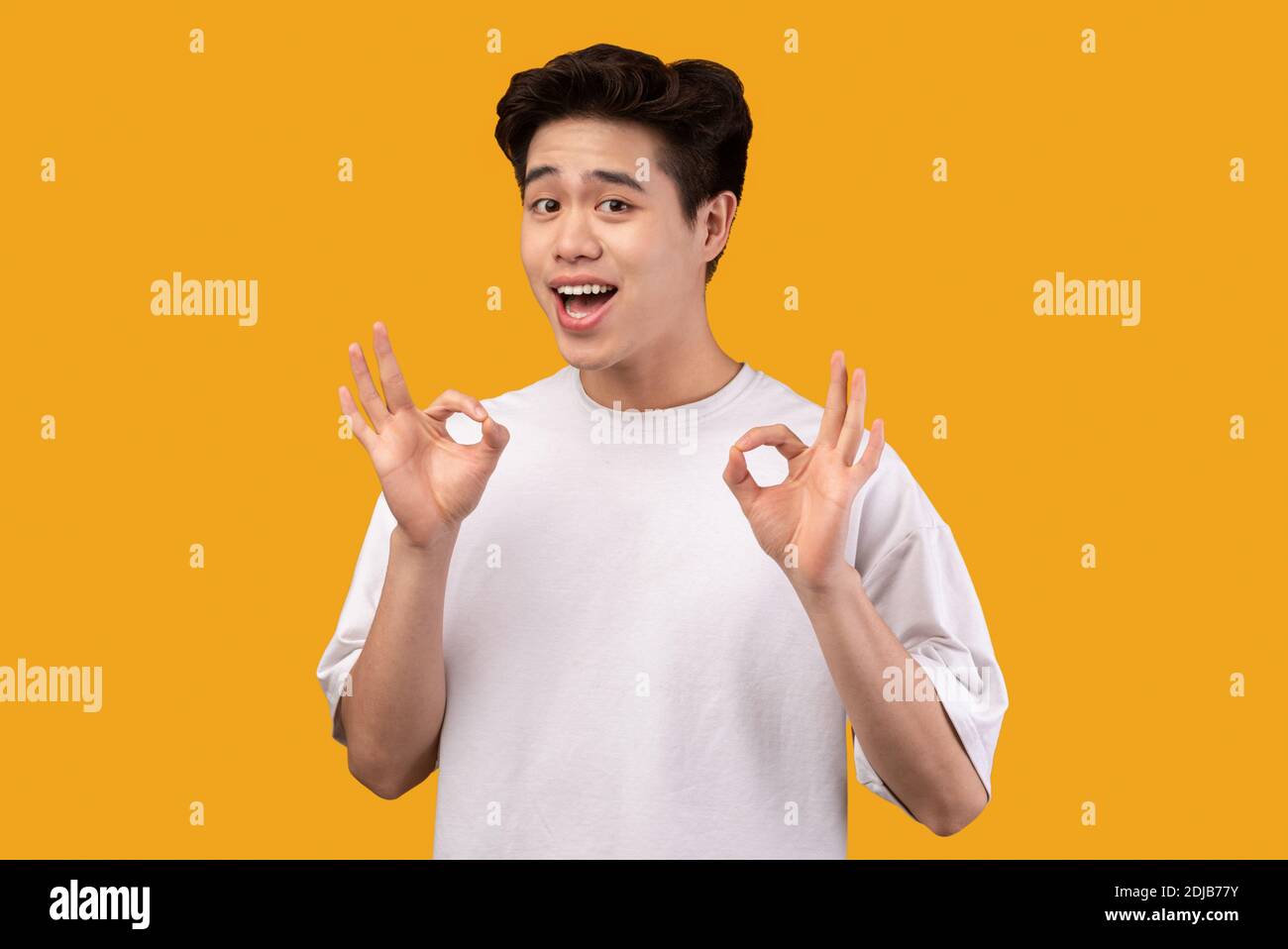 Happy asian young man gesturing okay and smiling Stock Photo