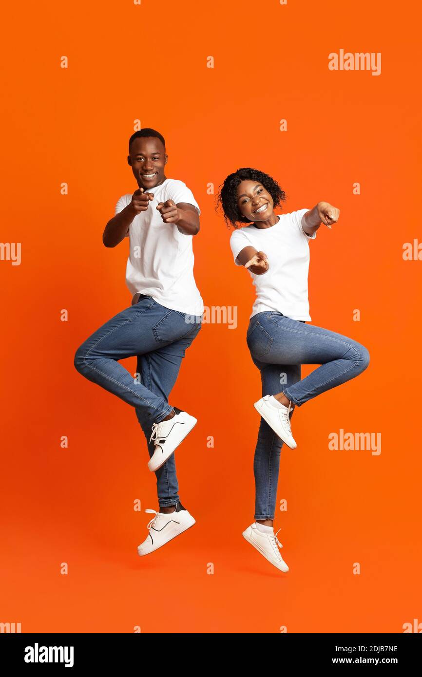 Emotional black couple posing on orange studio background Stock Photo