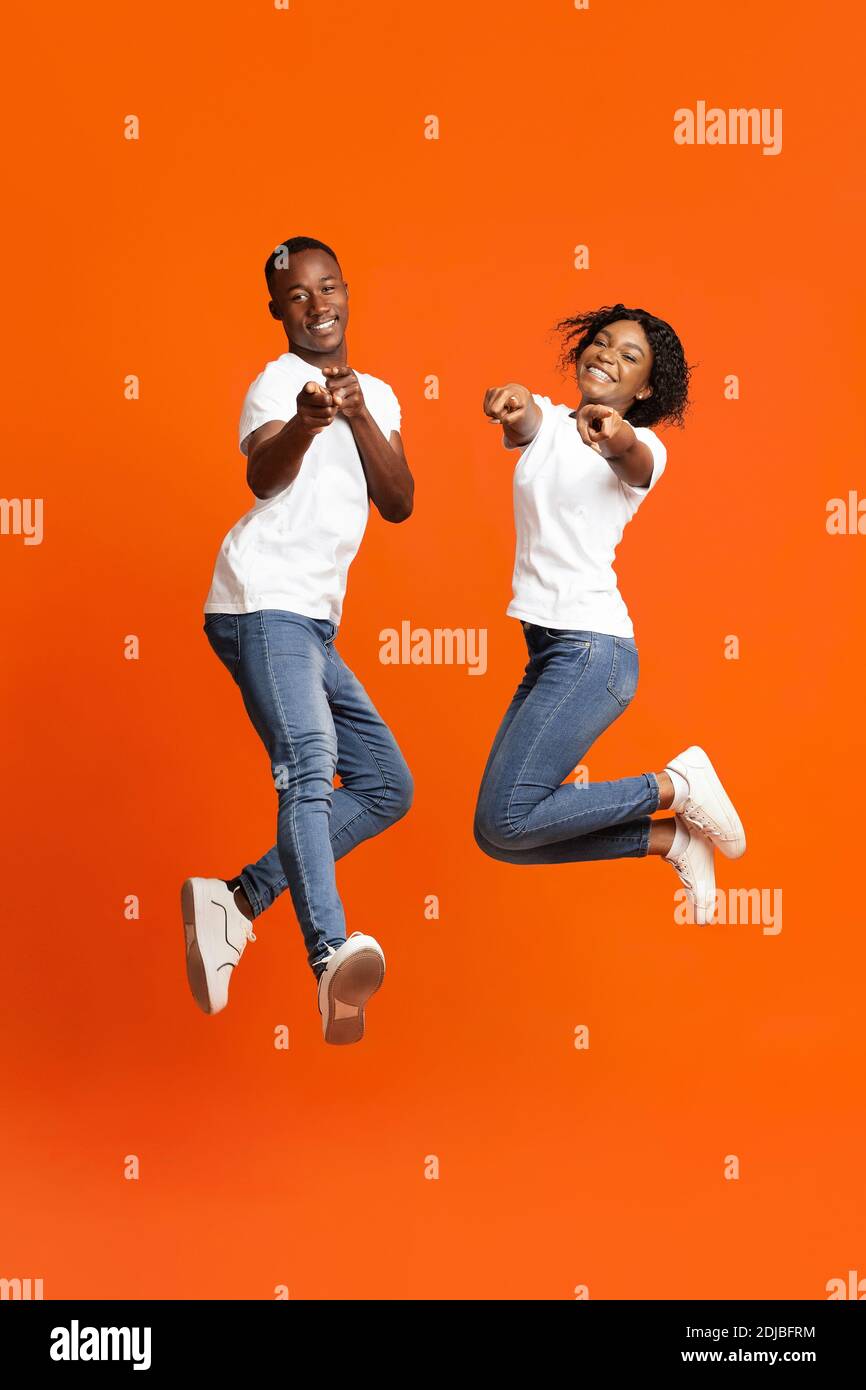 Happy black lovers posing on orange studio background Stock Photo