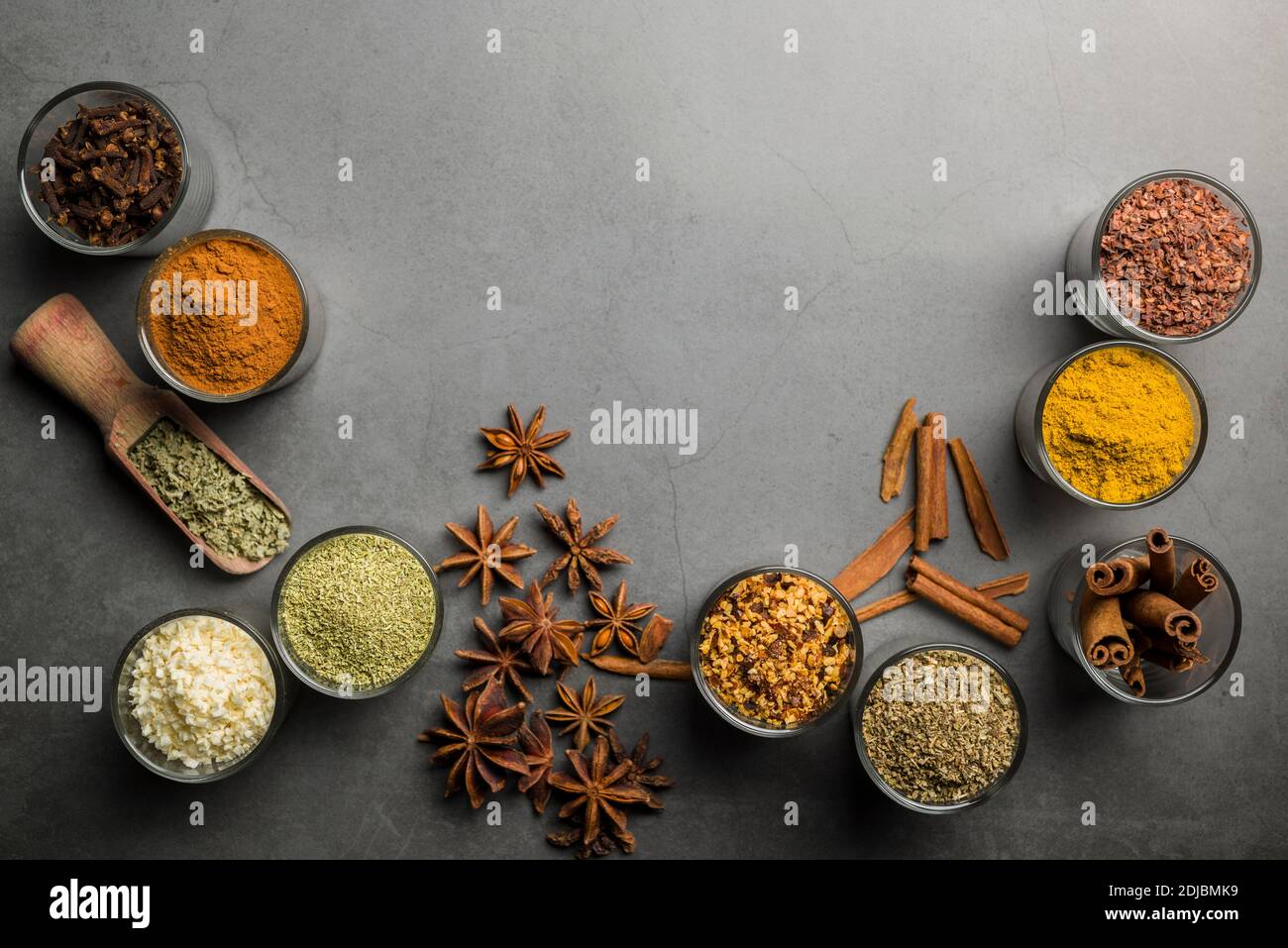 top view of glass jars with various spices on grey table Stock Photo