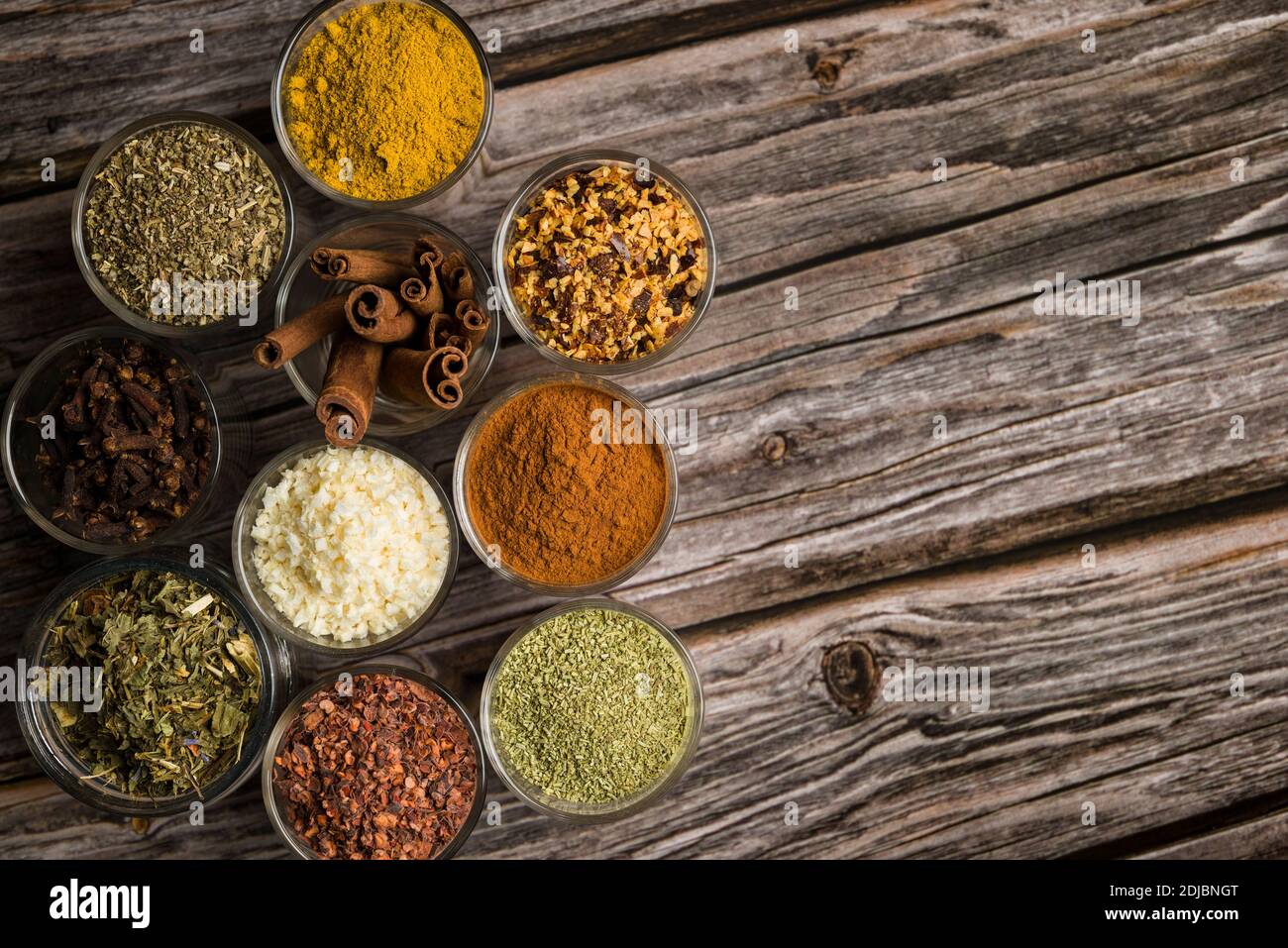 top view of glass jars with various spices on wooden table Stock Photo
