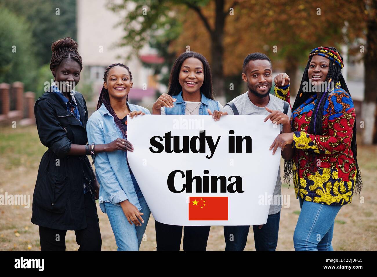 Study in China. Group of five african college students on campus at university yard hold white blank. Abroad countries for student concept. Stock Photo