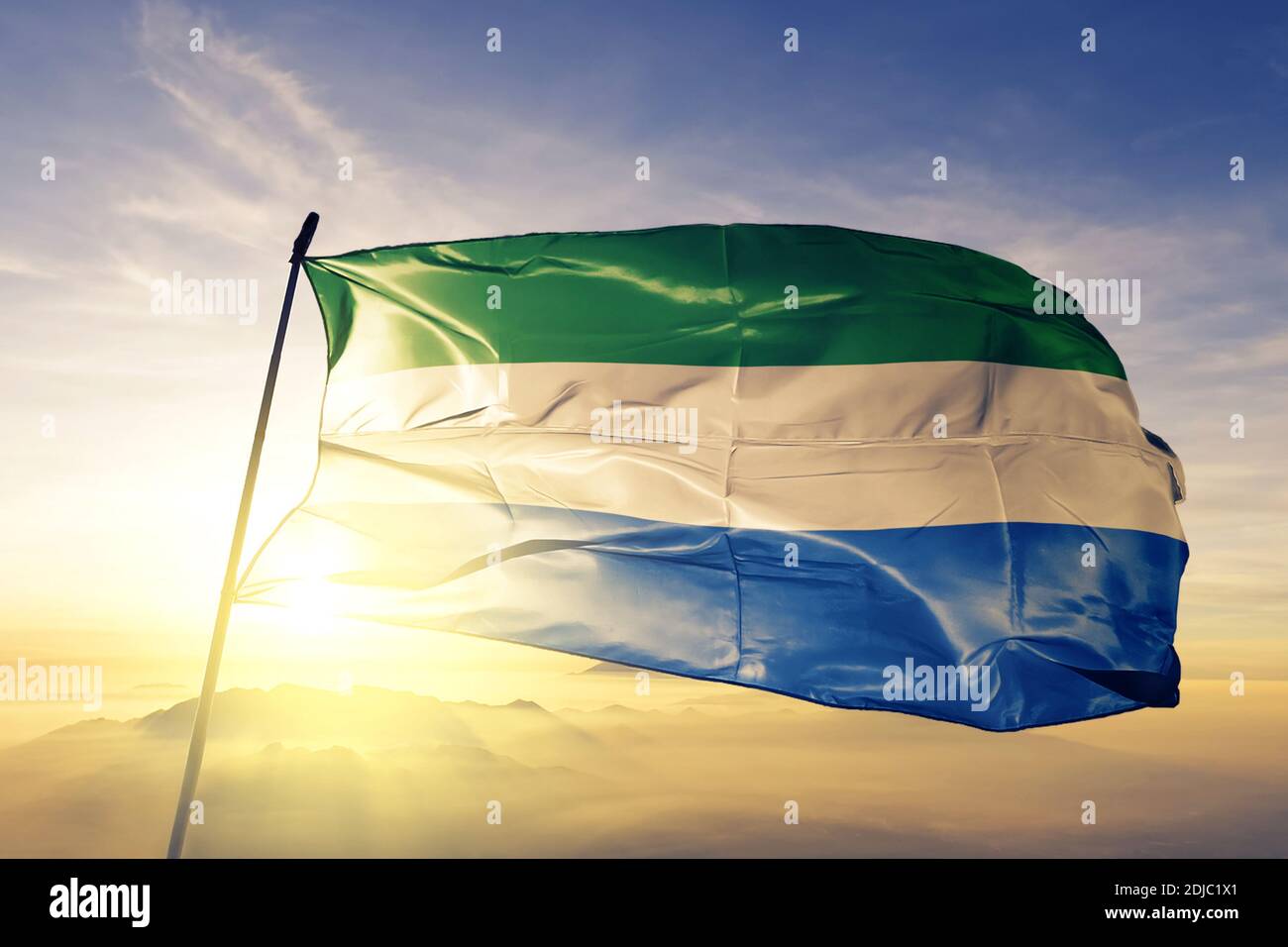 Sierra Leone flag waving on the top sunrise mist fog Stock Photo - Alamy