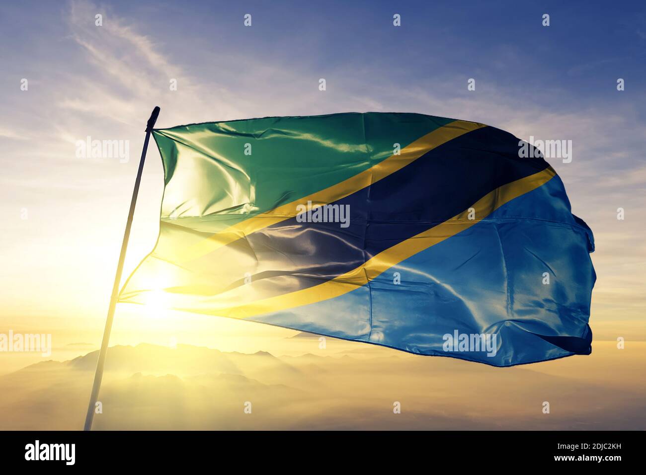 Tanzania flag waving on the top sunrise mist fog Stock Photo - Alamy