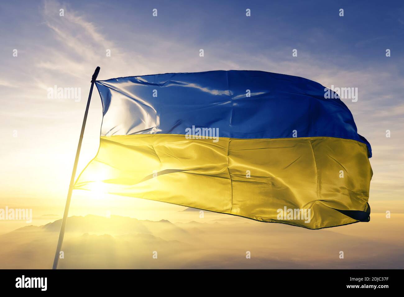 Ukraine flag waving on the top sunrise mist fog Stock Photo