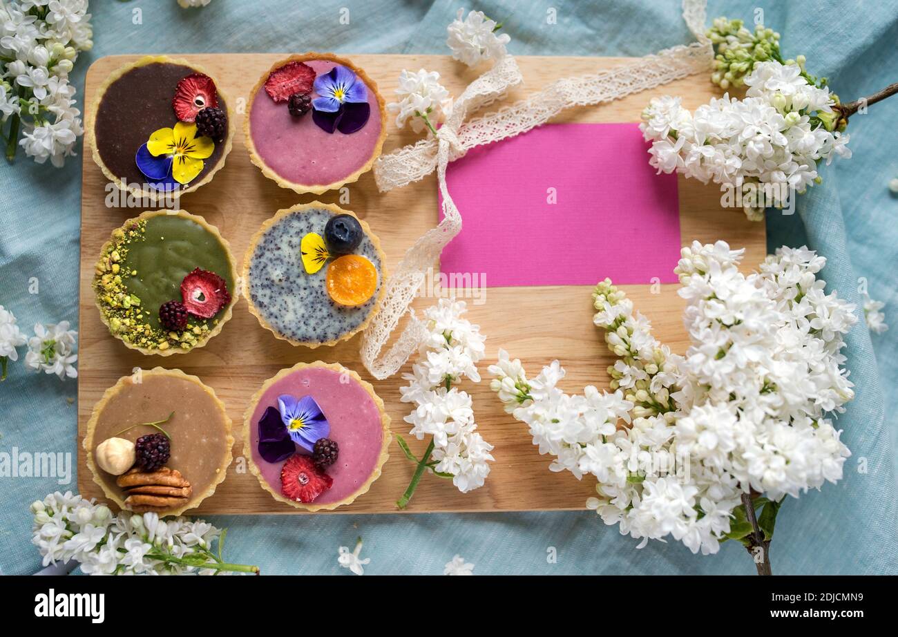 Top view of selection of colorful and delicious cake desserts in box on table. Copy space. Stock Photo