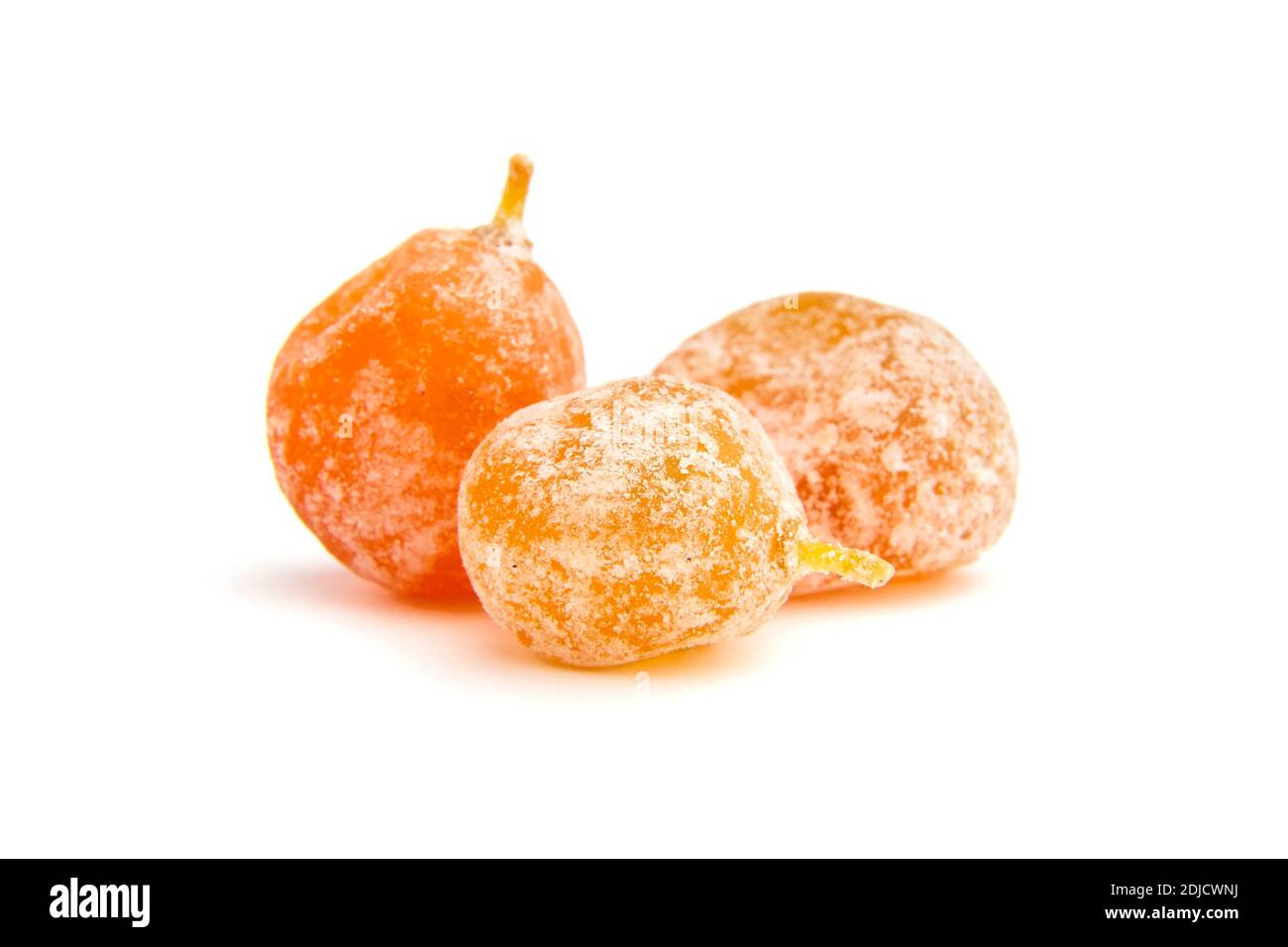 Candied fruits, three dried kumquats isolated on white background. Sugar coated kumquats Stock