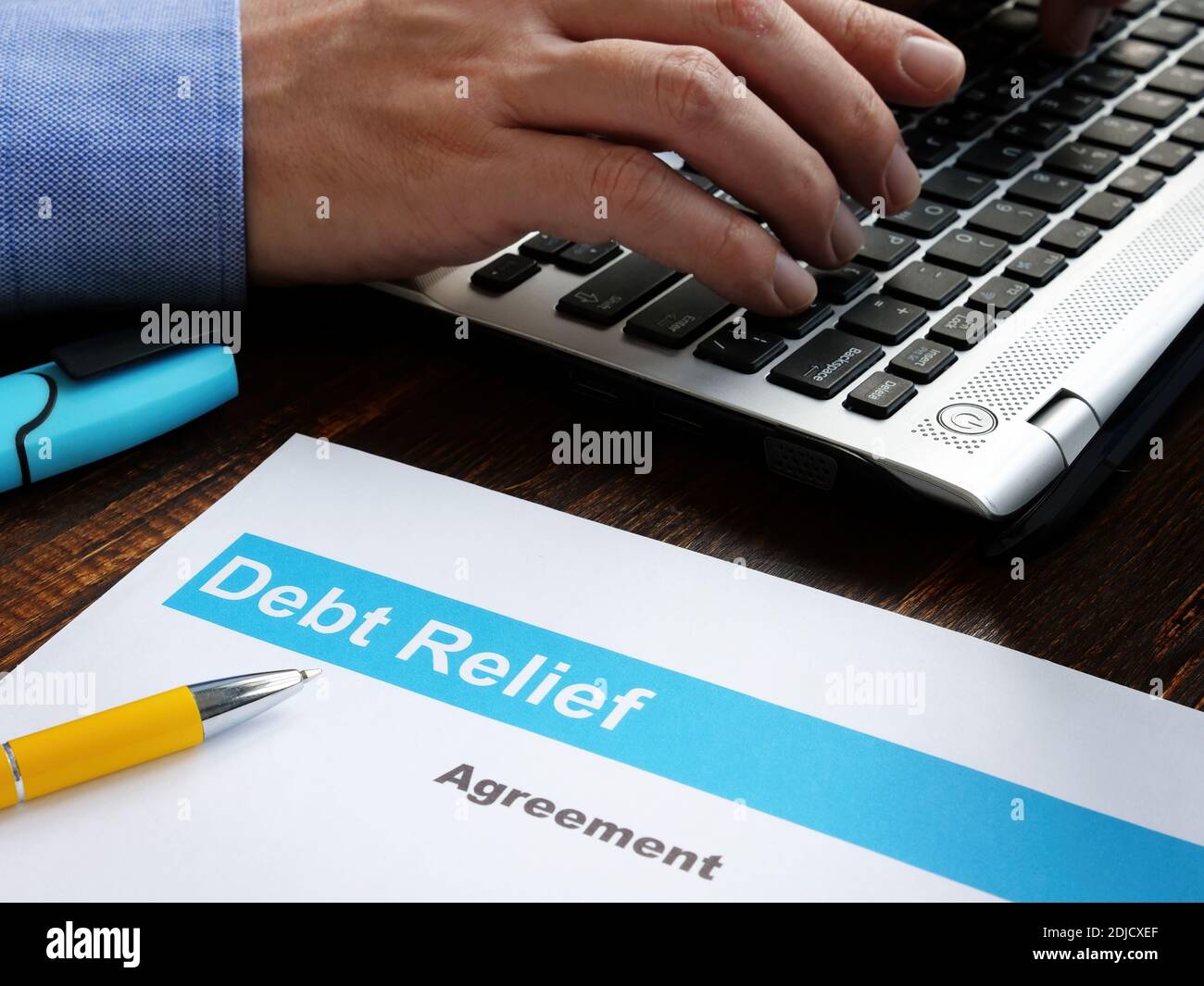 Debt relief agreement papers and man with laptop. Stock Photo