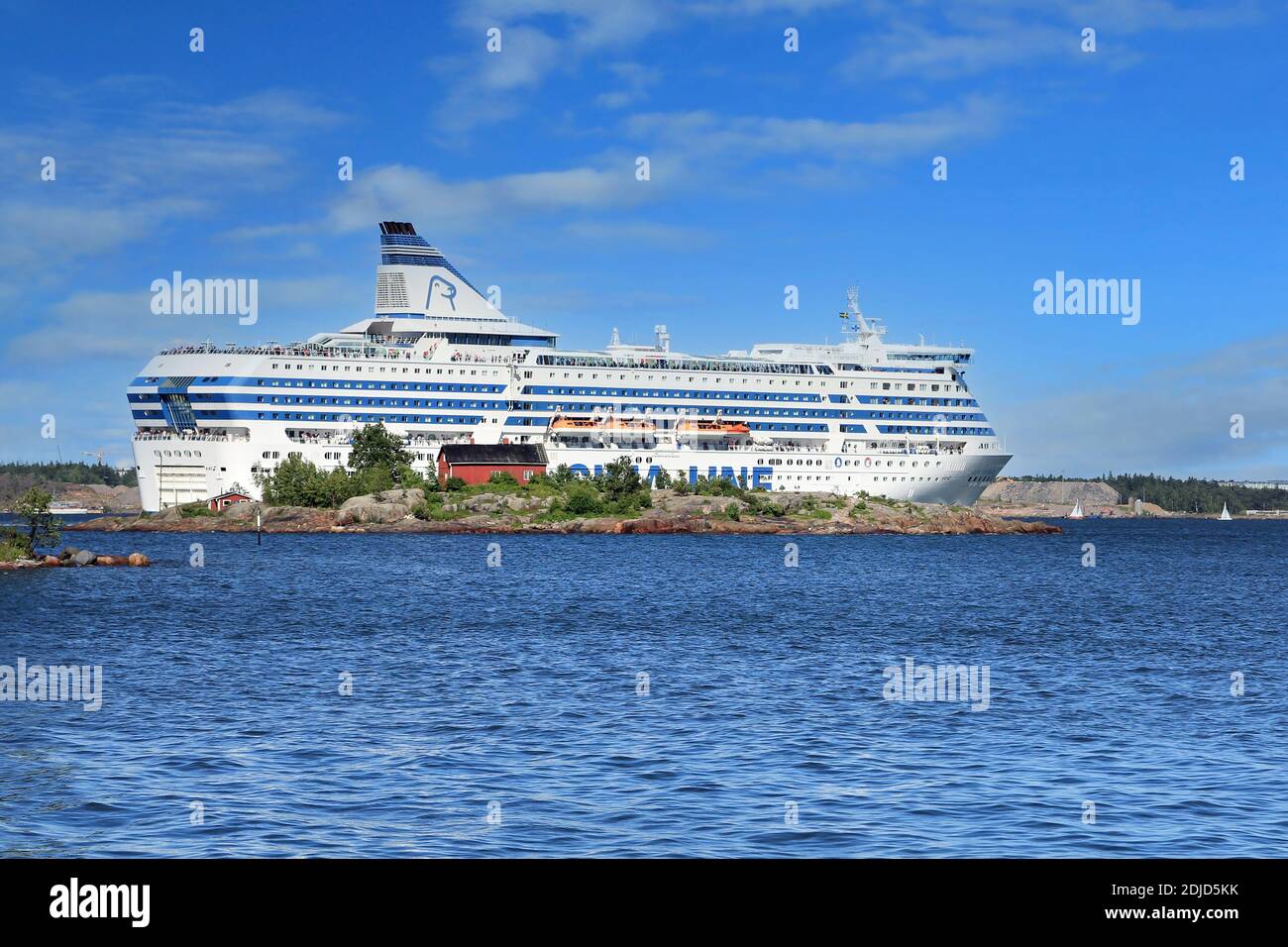 Silja Symphony cruise ferry sailing behind small Ryssansaari island after departing Helsinki, Finland on a sunny day of summer. June 28, 2017. Stock Photo