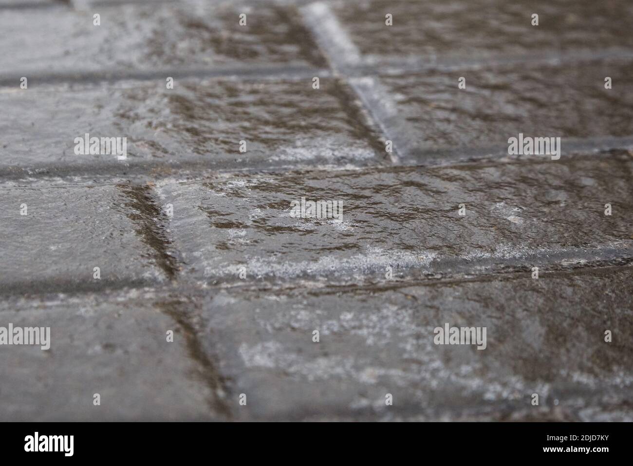 Ice crusted ground, paving slabs surface covered ice, slippery street