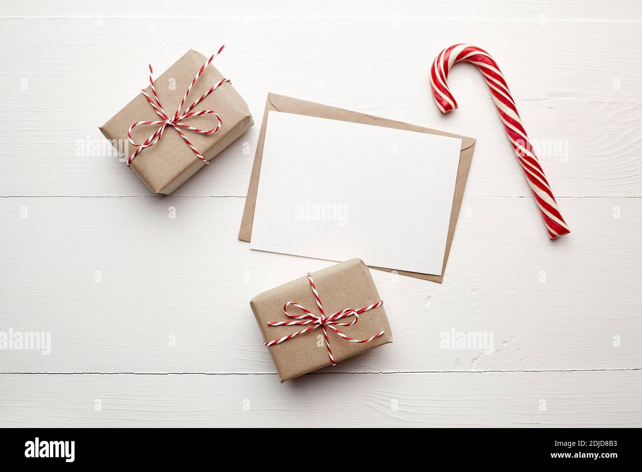 Christmas card mockup with gift boxes and candy cane on white wooden ...