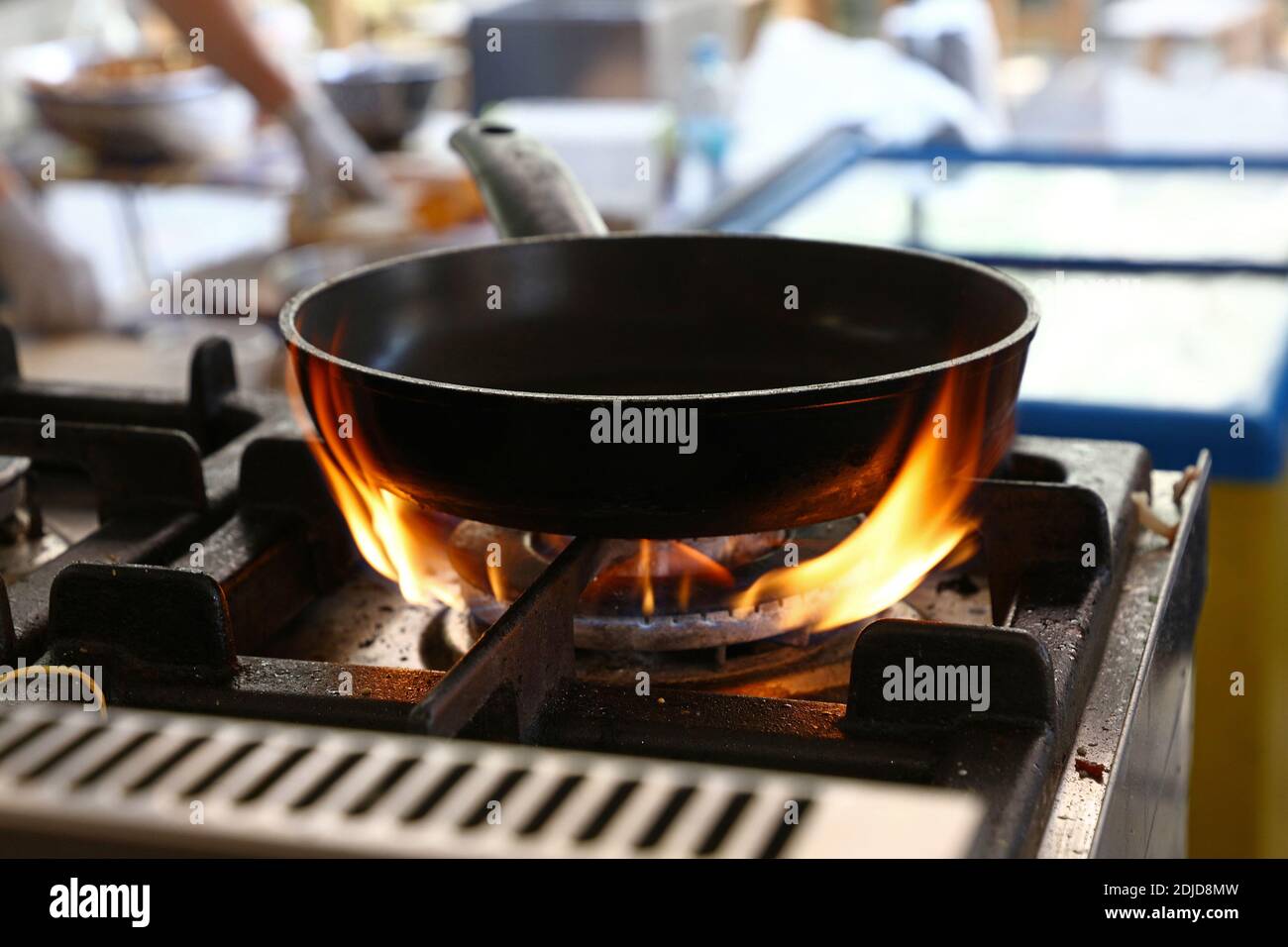 Close-up Of Cooking Pan On Burning Stove At Restaurant Stock Photo