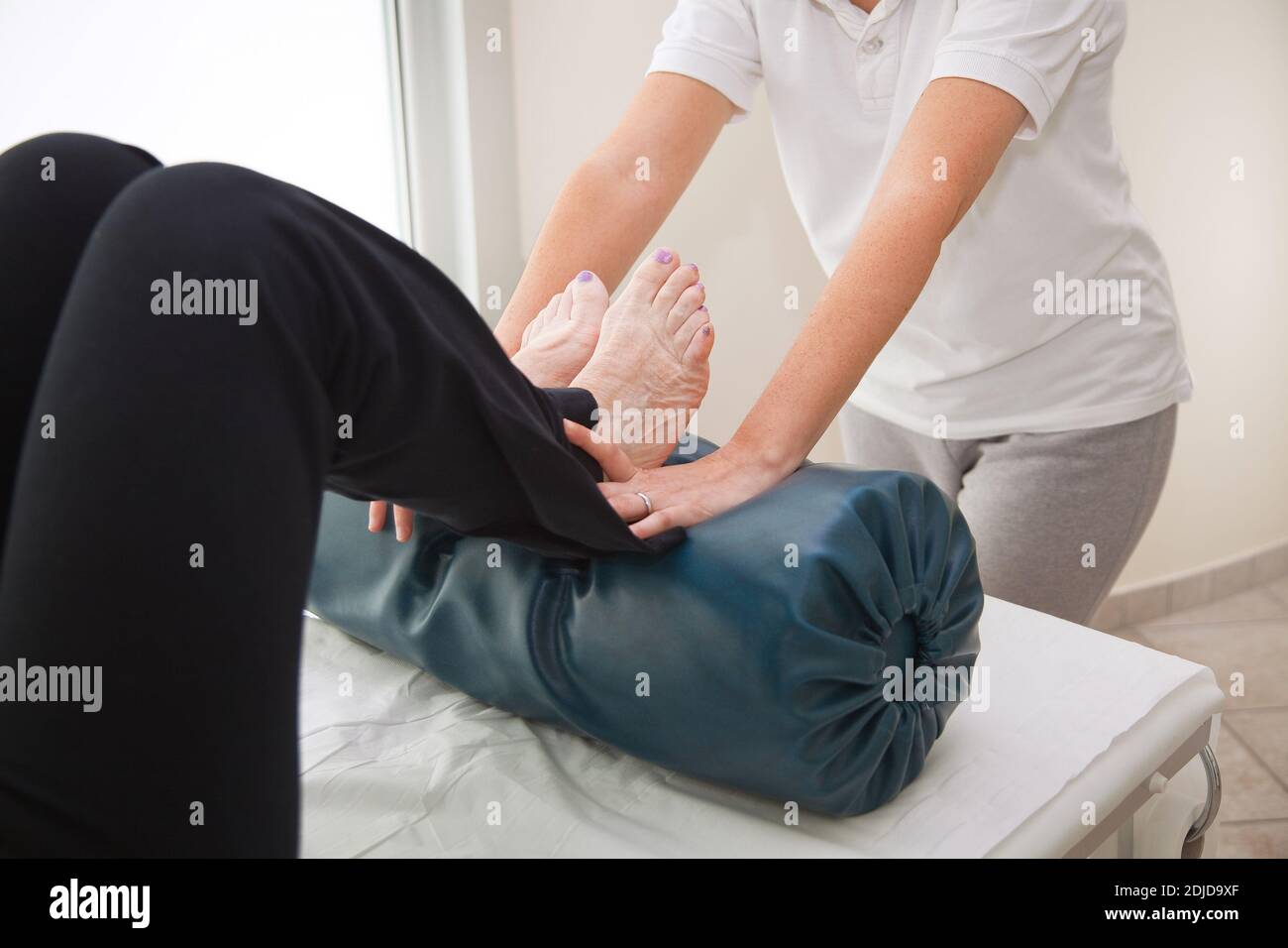 Midsection Of Healthcare Worker Holding Woman Legs Stock Photo