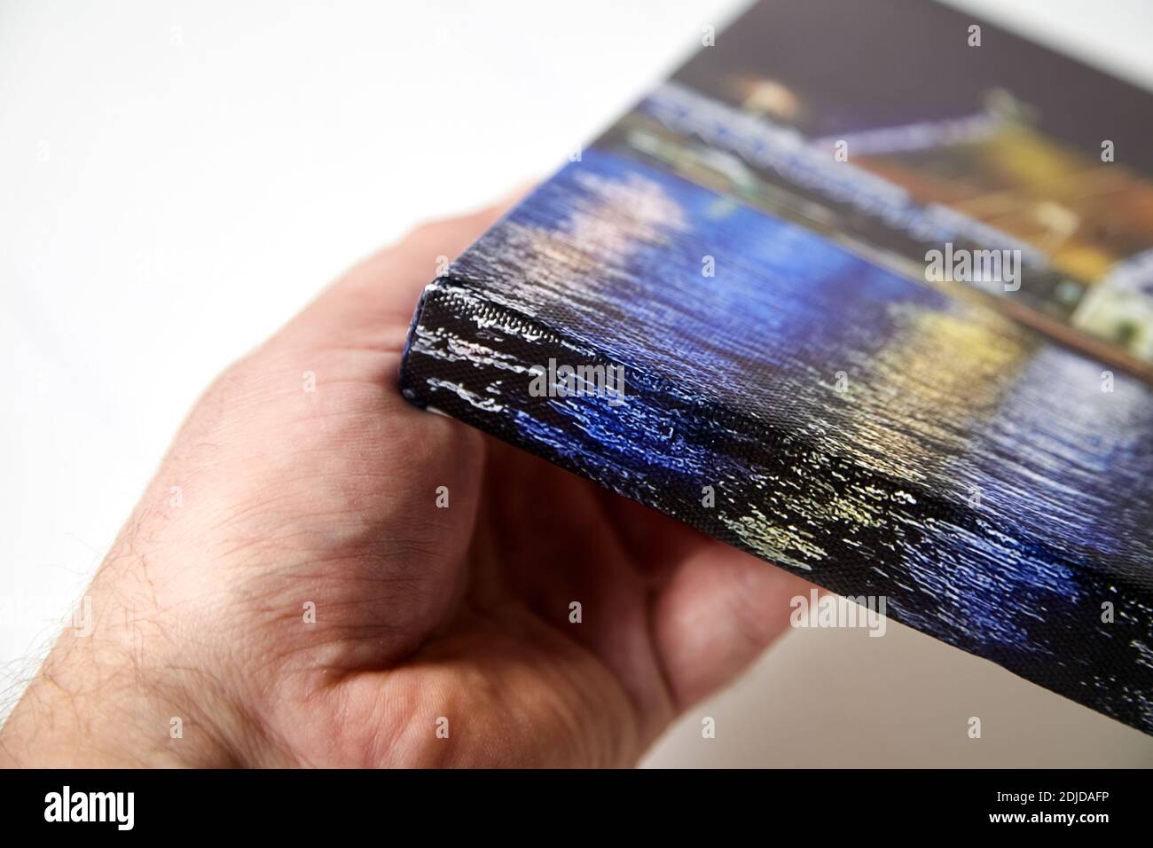 Canvas print. Hand holds a photo with gallery wrap method of canvas