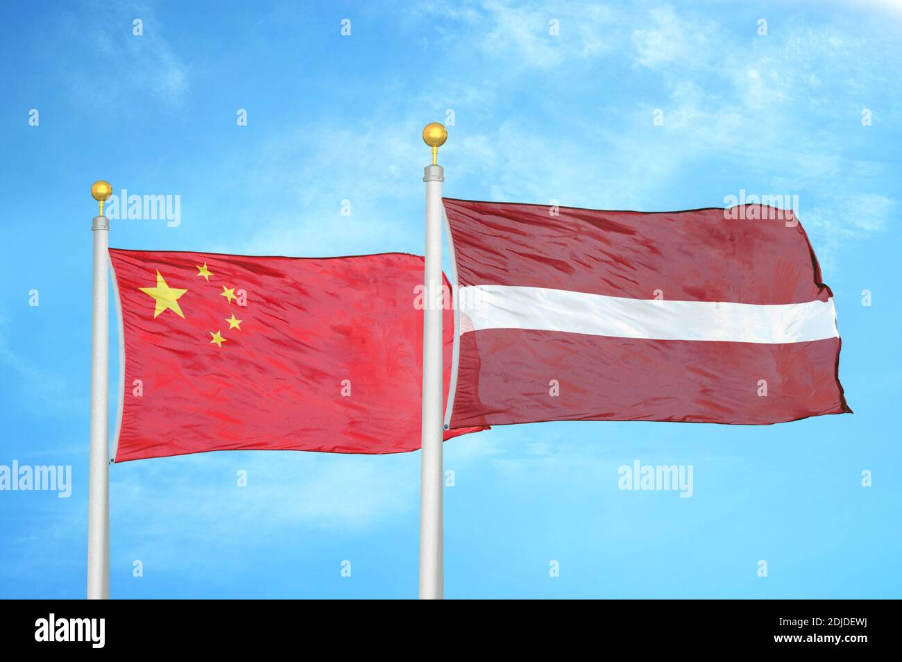 China and Latvia two flags on flagpoles and blue cloudy sky Stock Photo