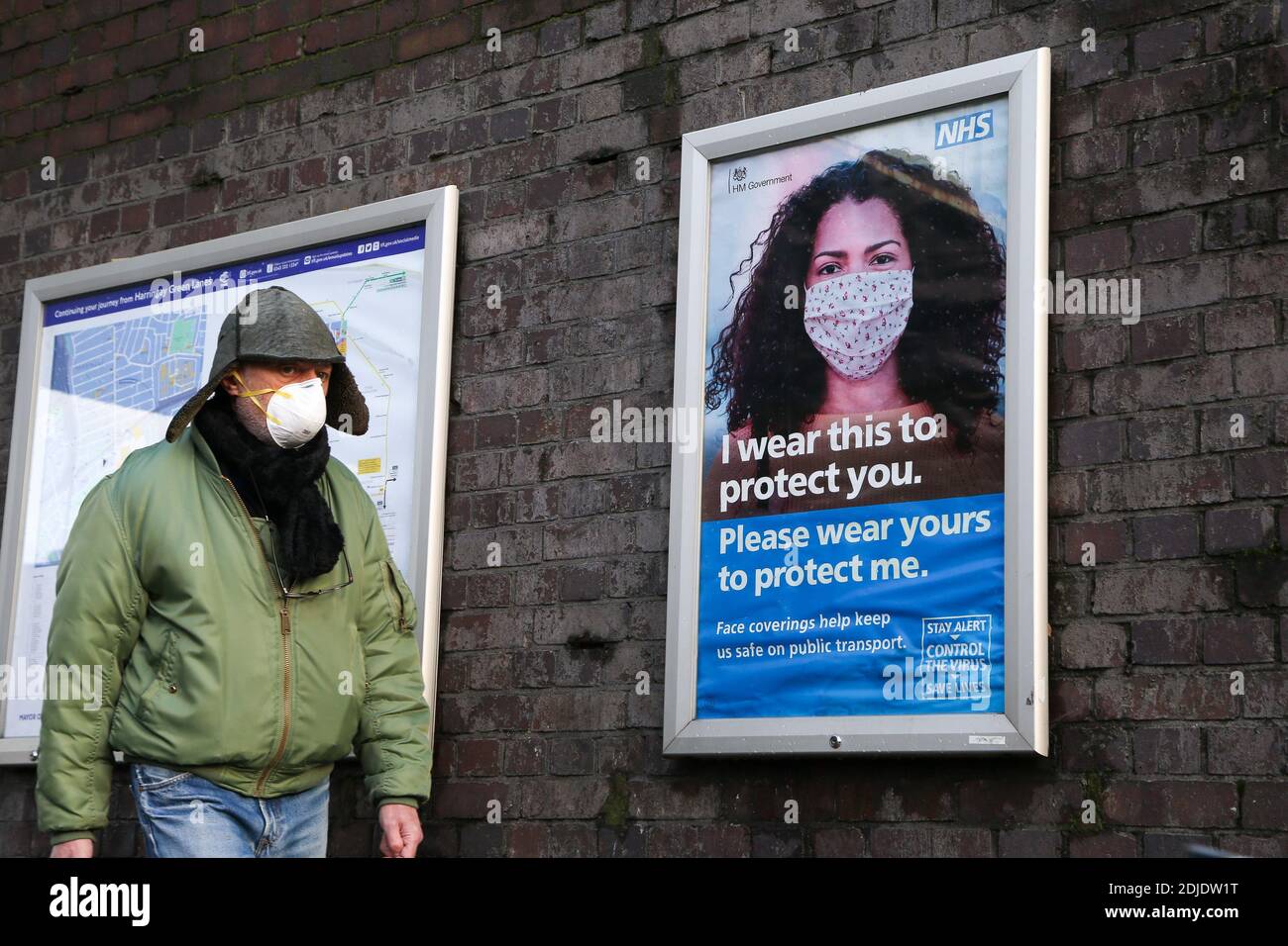 London, UK 14 Dec 2020 - A man wearing a face mask walk past the NHS COIVD-19 public information campaign poster in London. Health Secretary Matt Hancock has told London MPs that the capital will be moved into tier three COVID-19 restrictions imminently following a sharp rise in coronavirus infection rates.  Credit Dinendra Haria /Alamy Live News Stock Photo
