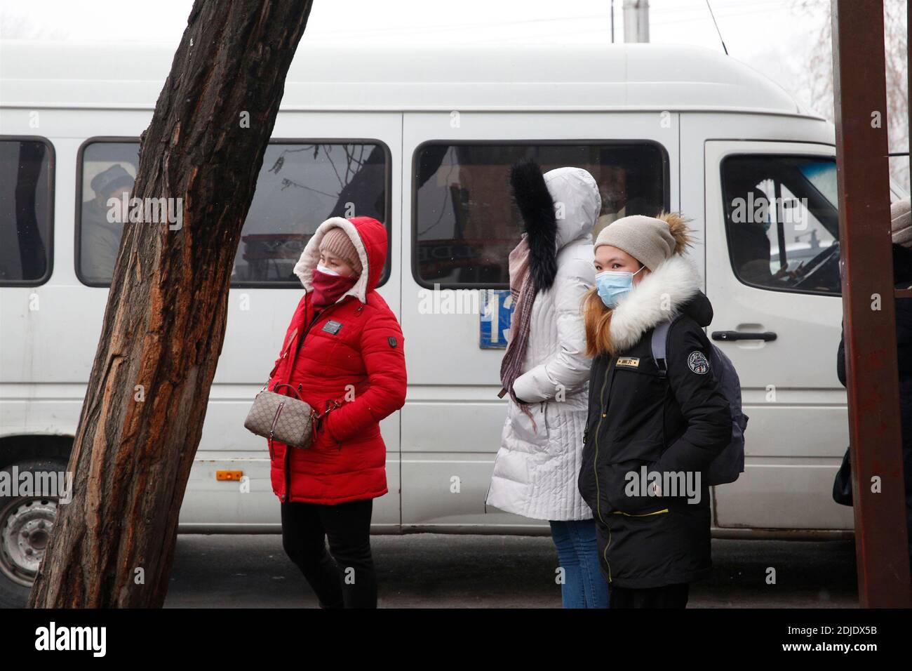 Bishkek, Kyrgyzstan. 14th Dec, 2020. Pedestrians wearing face masks wait for bus in Bishkek, Kyrgyzstan, Dec. 14, 2020. Kyrgyzstan's COVID-19 cases reached 77,674 on Monday as 318 new cases were registered across the country over the past 24 hours. Credit: Roman/Xinhua/Alamy Live News Stock Photo