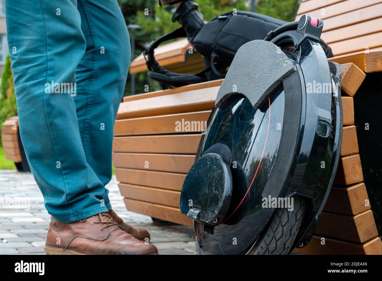 An electric mono wheel, an innovative personal vehicle, a self-balancing electric unicycle, an ecological urban transport of the future, a man in jean Stock Photo